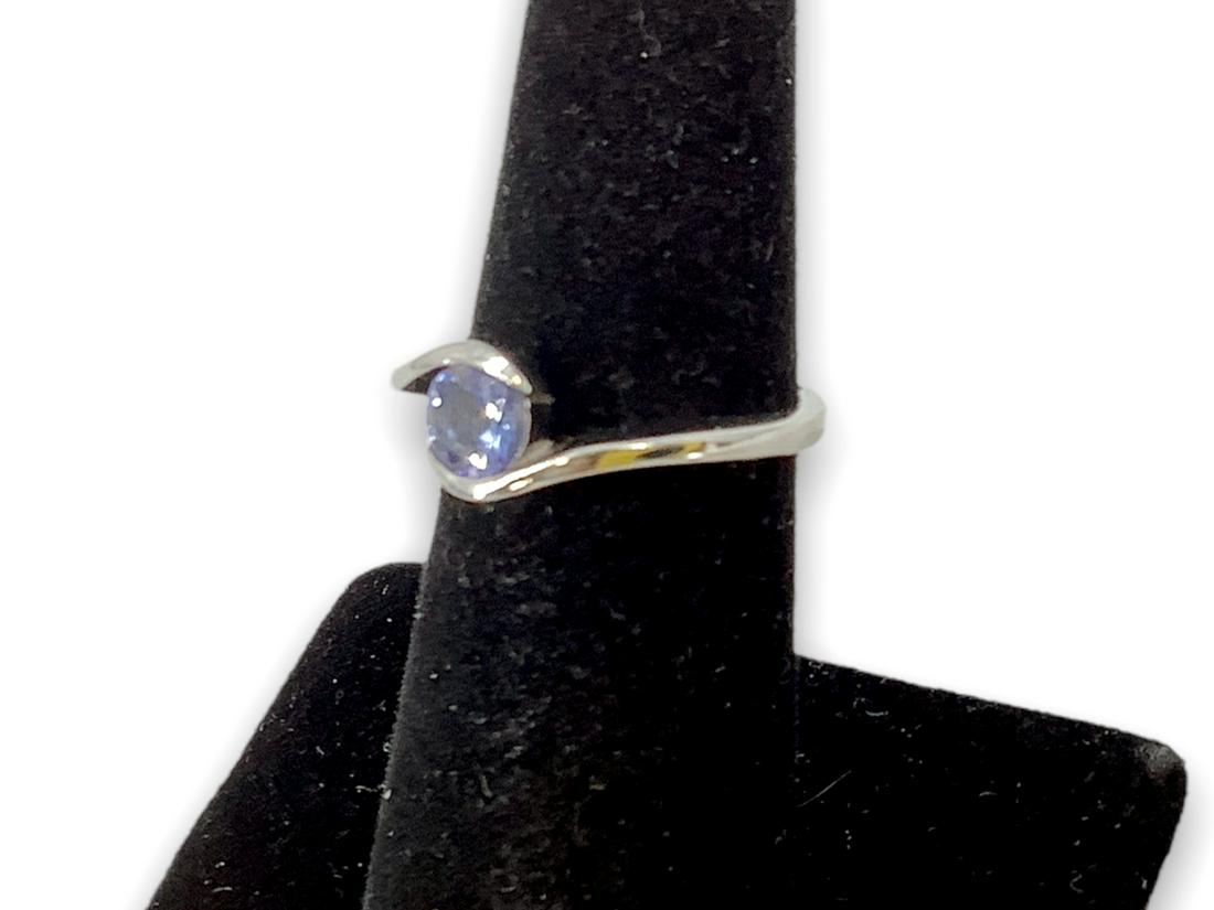 Tanzanite Solitaire Ring: Tanzanite Solitaire Ring Sterling silver (stamped and tested 925), signed D'Joy, 0.10 troy ounces total weight, size 6 with bypass shank, high polish metal finish, round cut tanzanite center stone mea