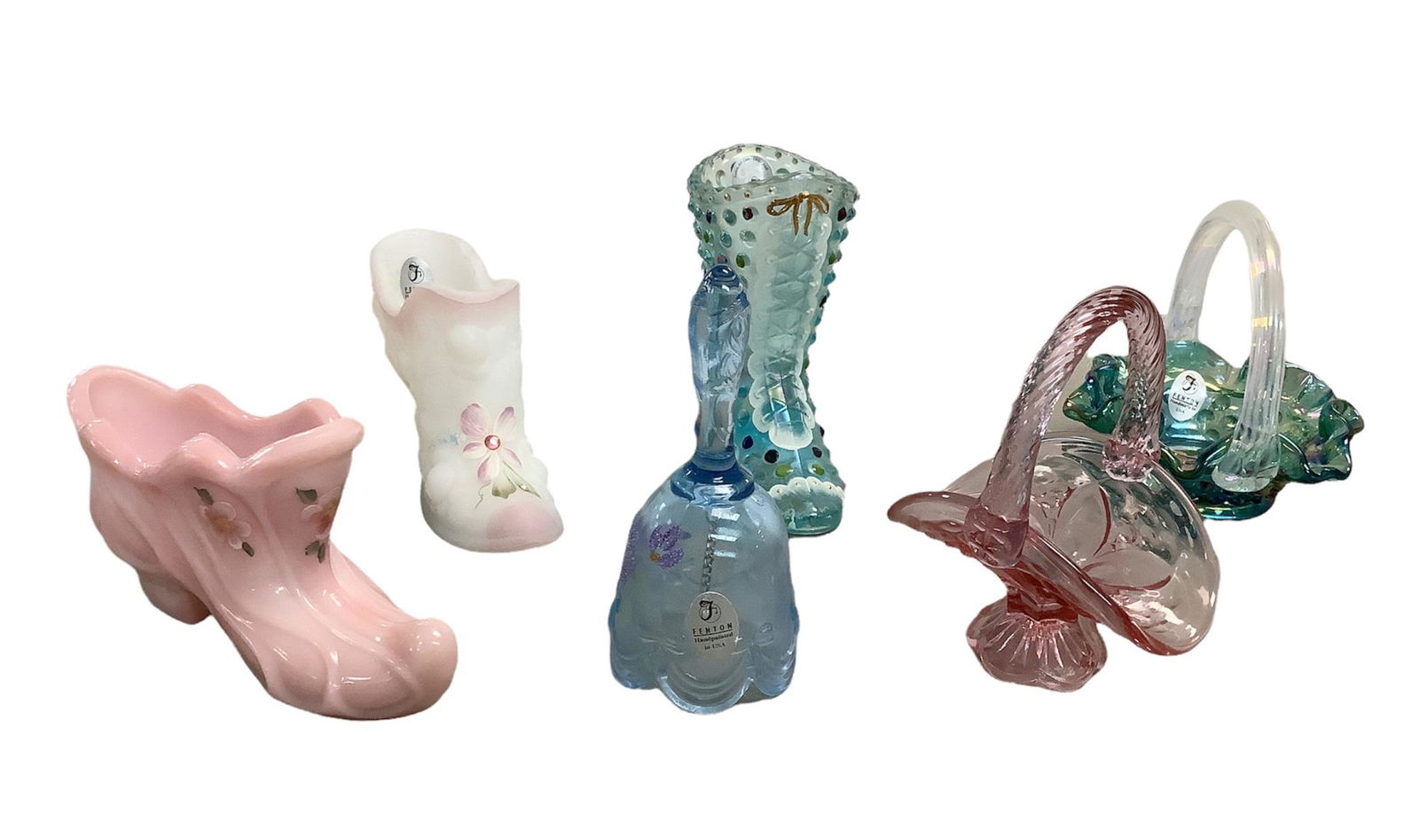Boots, baskets and a bell! Lot of six Fenton Art Glass collectibles. Boots and bell signed by: Boots, baskets and a bell! Lot of six Fenton Art Glass collectibles. Boots and bell signed by artists. Blue boot has 95th Anniversary sticker and measures 3 1/2” x 4” tall. Pink boot measu