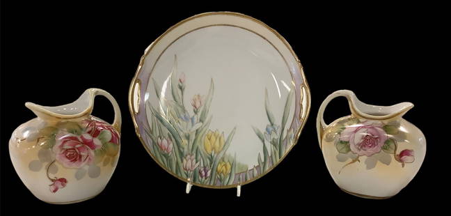 2 small hand painted Nippon pitchers a with rose design. Picture shows front on 1 and back on the: 2 small hand painted Nippon pitchers a with rose design. Picture shows front on 1 and back on the other. Pitchers are 5.5" tall and wide. Also includes a floral 2 handled serving plate 9.25" diameter.