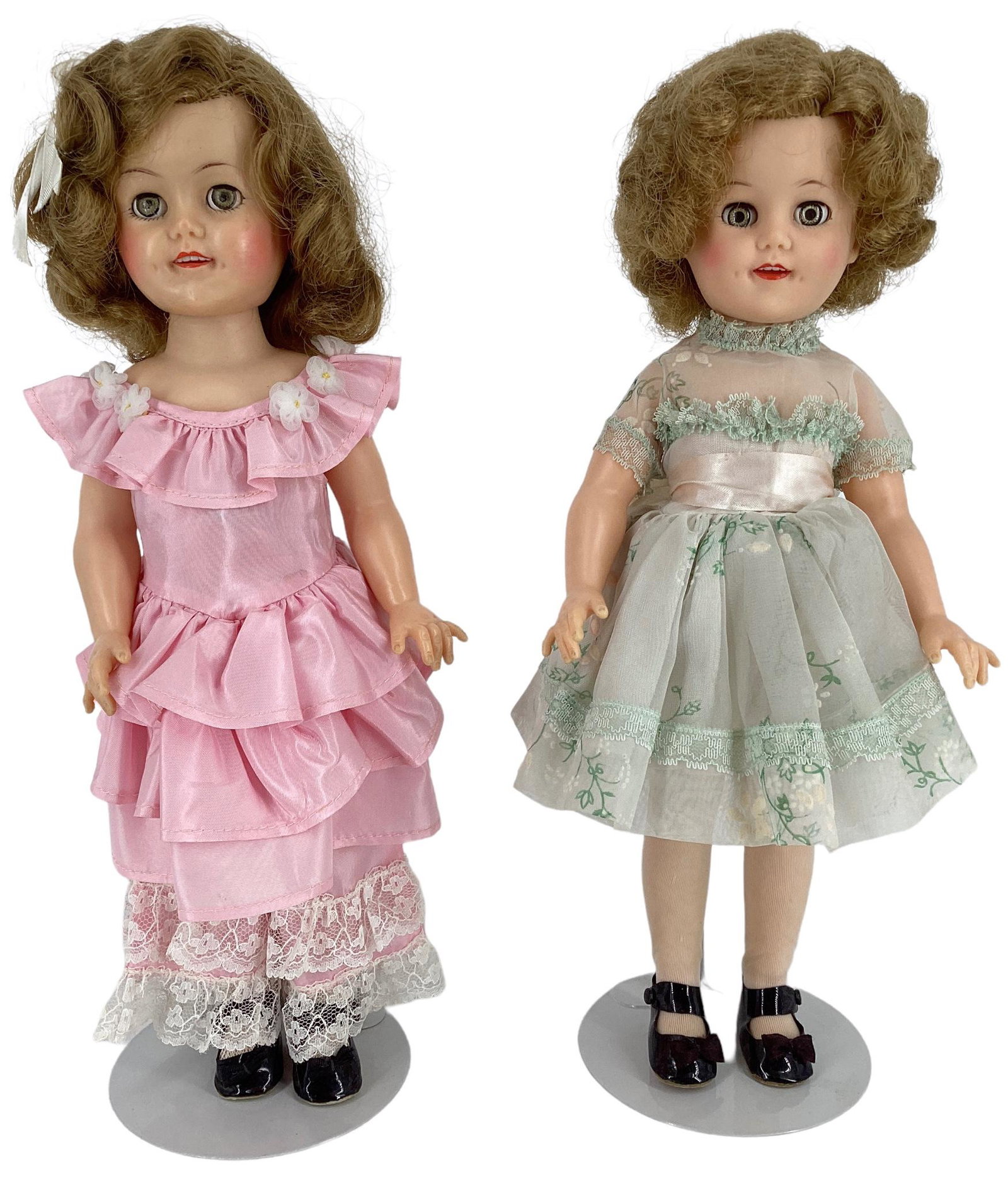 Pair of Ideal Shirley Temple 14" dolls hard plastic, rooted mohair wigs, molded eyelashes, glass: Pair of Ideal Shirley Temple 14" dolls hard plastic, rooted mohair wigs, molded eyelashes, glass sleep eyes, open mouth with teeth and painted facial features. One doll has a green organdy flower prin