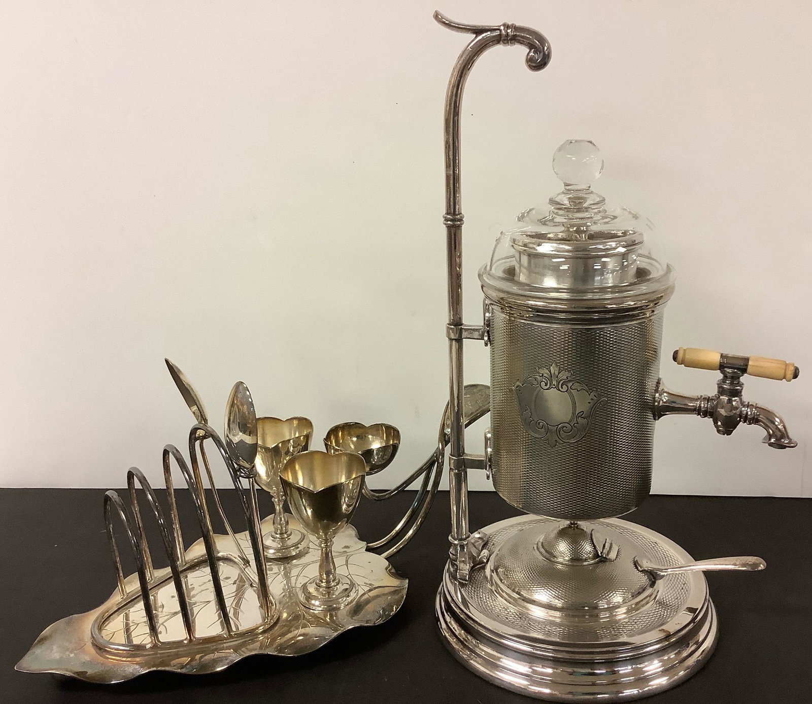 Charming breakfast lot includes a silverplated leaf-shaped toast holder w/spoons for jelly marked: Charming breakfast lot includes a silverplated leaf-shaped toast holder w/spoons for jelly marked EPNS, removable egg cups and a “flower” to hold butter or other condiment. Other item is a