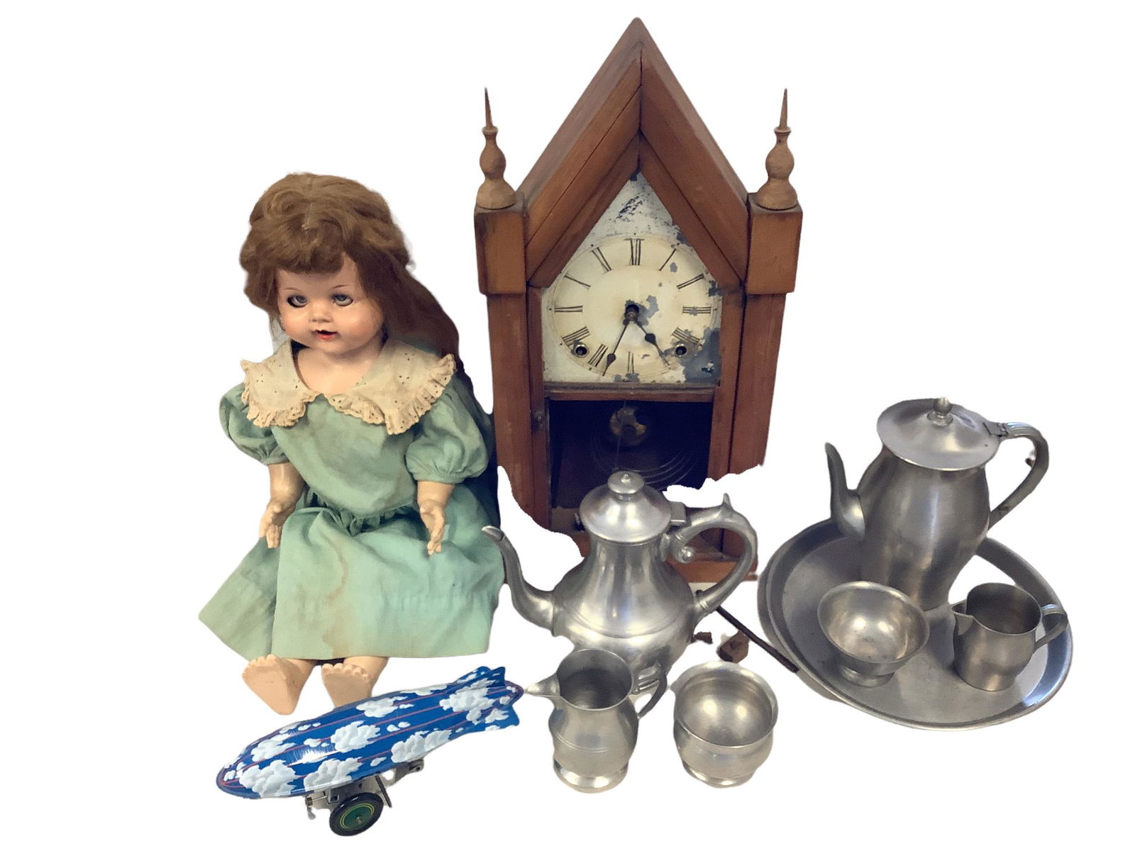A mixed lot of 10 consisting of 2 pewter tea sets, a hard plastic Ideal doll, a wind up zeppelin (1 of 8)