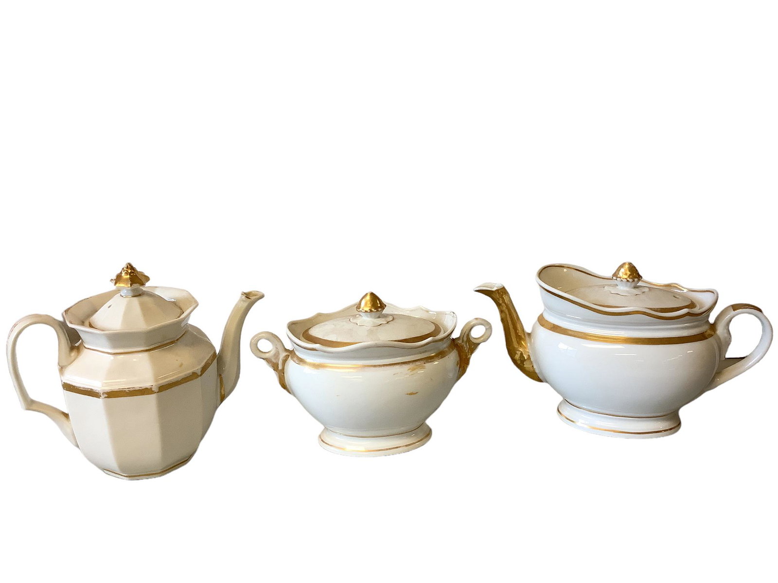Lot of 3 pieces of porcelain including 2 teapots and a table sugar. They range in size from 8”: Lot of 3 pieces of porcelain including 2 teapots and a table sugar. They range in size from 8” tall to 6 1/2” tall. There is damage to each piece.