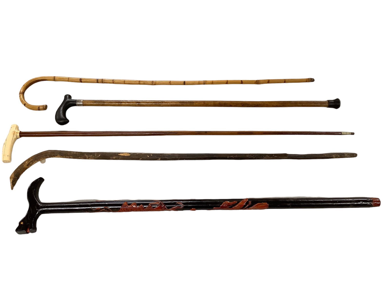 Lot of 5 wood canes including a 35” carved dragon themed cane, a 36” tree branch cane: Lot of 5 wood canes including a 35” carved dragon themed cane, a 36” tree branch cane that has a split, a 38” cane with a animal bone handle, a 35 3/8” bamboo cane and a 32 1/4