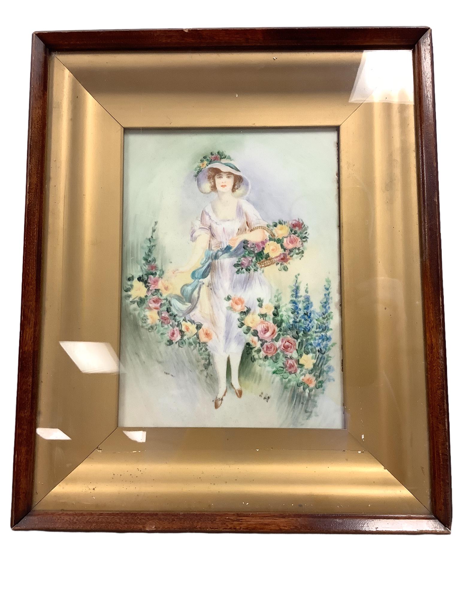 Framed tile with hand painted lady in flower garden. The frame is 10 1/4" x 12 1/2". The tile is 6": Framed tile with hand painted lady in flower garden. The frame is 10 1/4" x 12 1/2". The tile is 6" x 9".