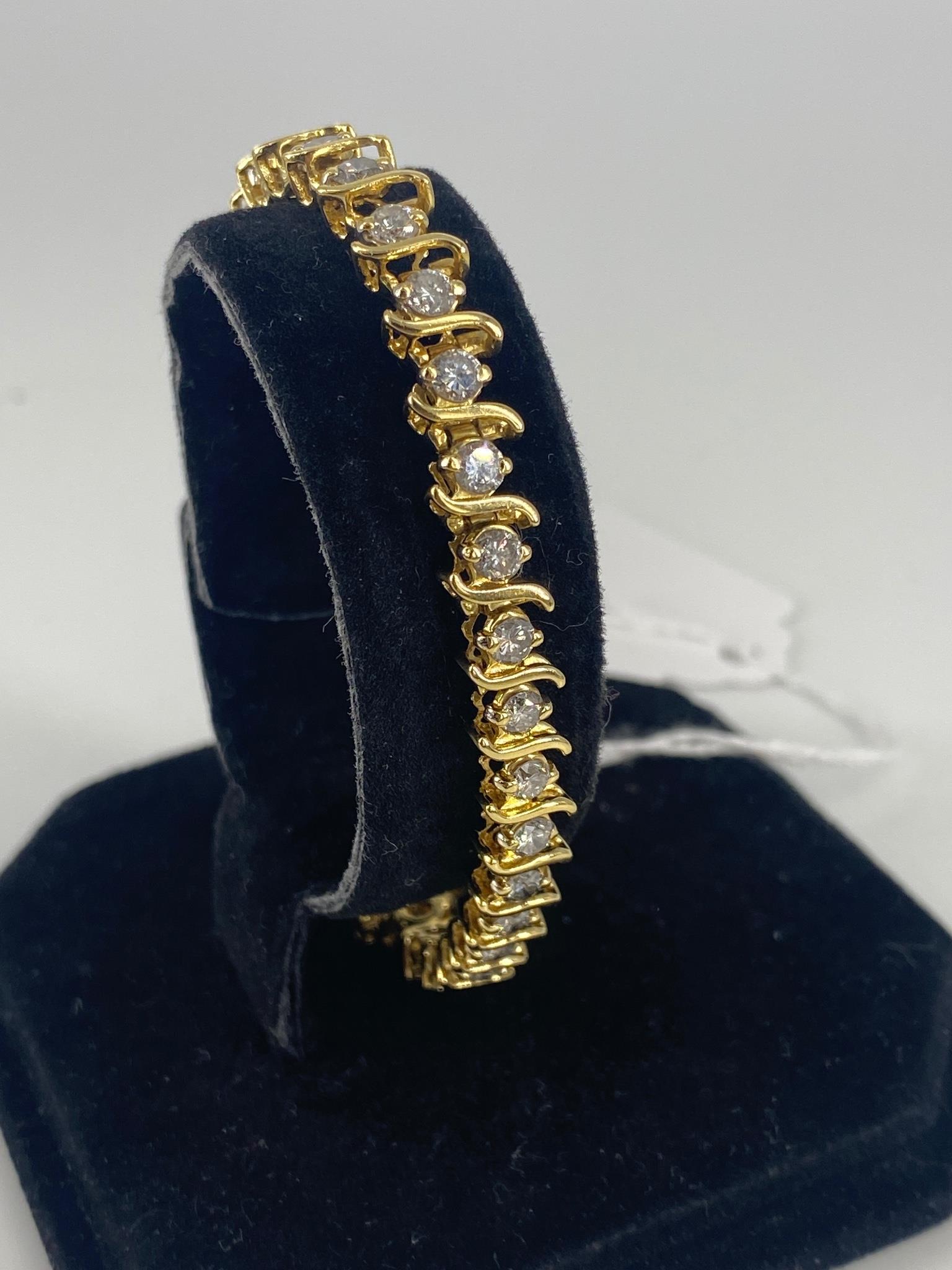 18kt Yellow Gold Diamond Tennis Bracelet: 18kt Yellow Gold Diamond Tennis Bracelet Measuring approx, 7.3Ã® in length (6.4mm) containing brilliant diamond rounds in tension style mountings alternating with polished Ã¬SÃ® shaped links (20