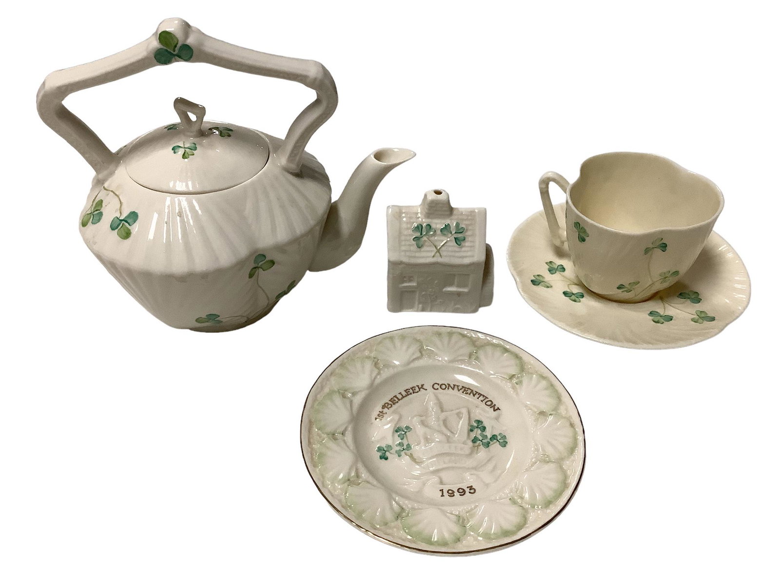 Lot of five pieces of Belleek including a 6.75"h Harp Shamrock tea kettle, a Harp Shamrock 2.5"h cup: Lot of five pieces of Belleek including a 6.75"h Harp Shamrock tea kettle, a Harp Shamrock 2.5"h cup with saucer, a 2.75" h eleventh edition Ballymist Mill ornament and a 5.25" diameter 1st convention