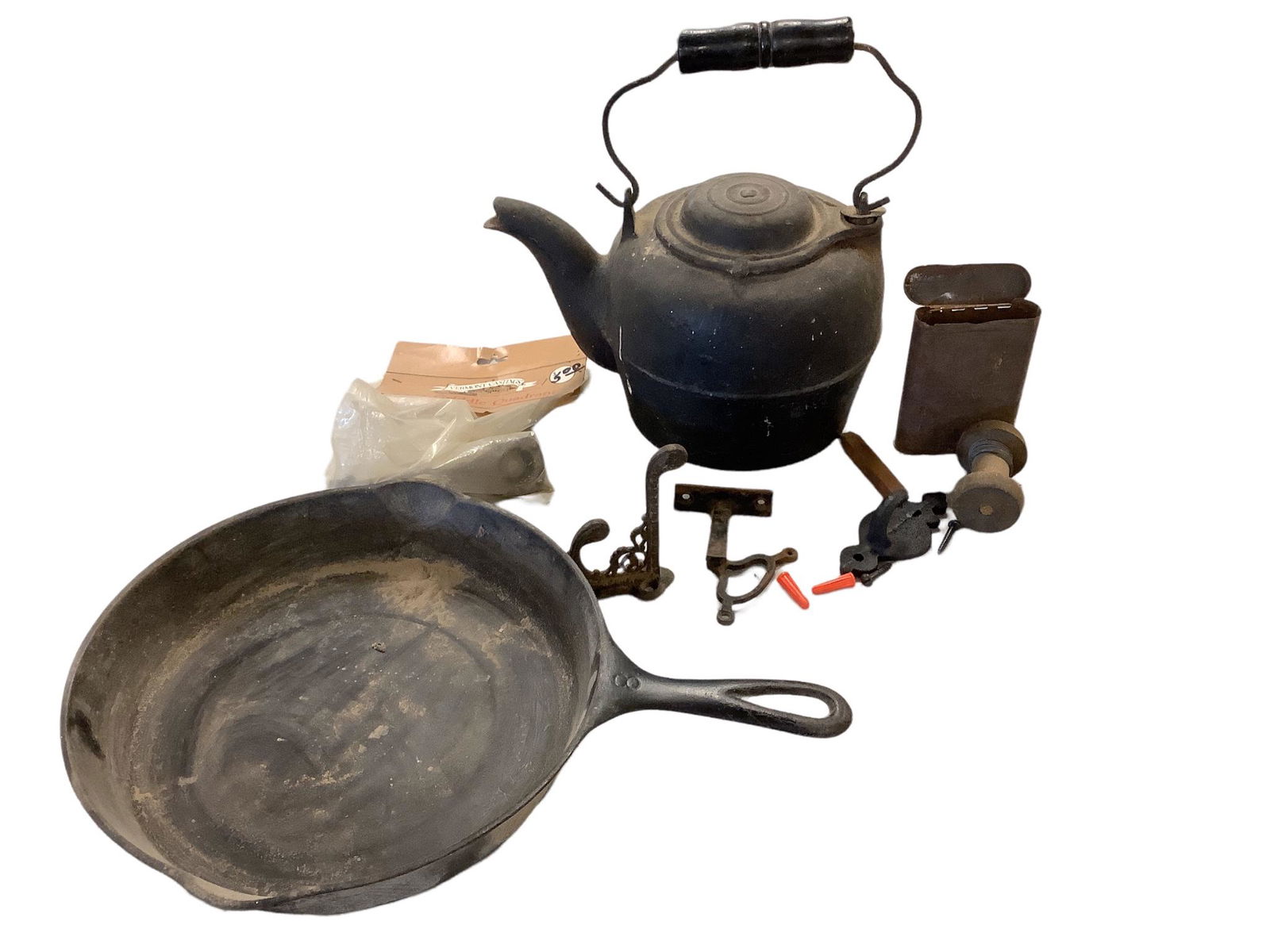 Lot of cast iron items including a 10" fry pan, kettle w/wood handle, metal box filled w/metal bit (1 of 2)