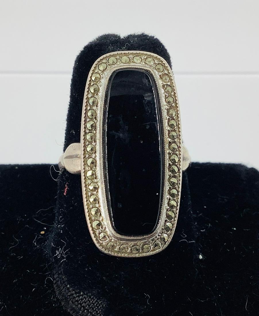 Sterling and Onyx Stone Ring: Sterling and Onyx Stone Ring Stamped and tested, signed Theda, 4.0 dwt., 21.5mm onyx center stone, with halo of marcasite stone accents. Adjustable shank size.
