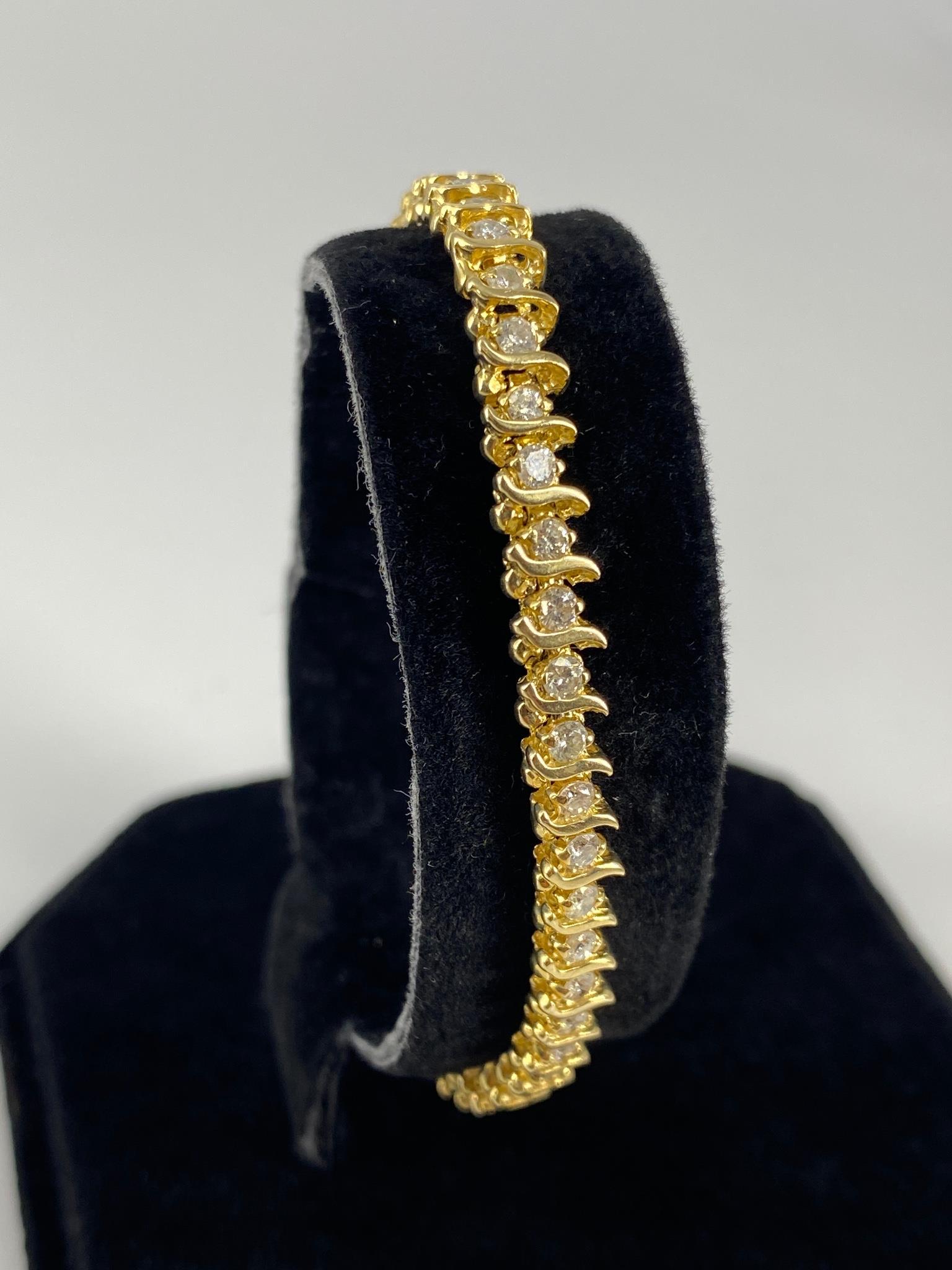 14kt Yellow Gold Diamond Tennis Bracelet: 14kt Yellow Gold Diamond Tennis Bracelet Measuring 6.5” in length featuring curved bar links containing (49) diamond rounds (approx. I-I1 1.96ct tdw) (11.9 grams tw). Total Appraised Value - $4,