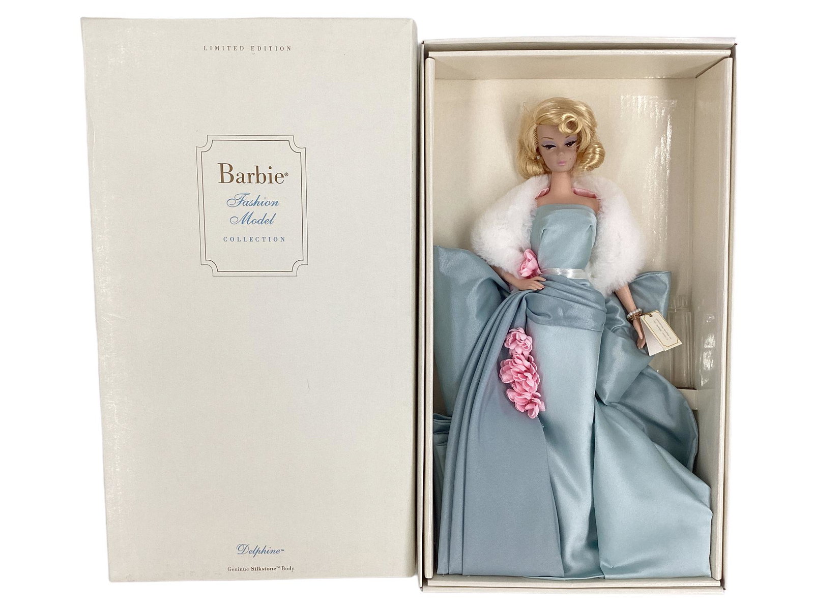 BFMC DELPHINE BARBIE W/ SILKSTONE Body and wears a gorgeous light blue gown with,pink flowers: BFMC DELPHINE BARBIE W/ SILKSTONE Body and wears a gorgeous light blue gown with,pink flowers adorning her gown as well as jewelry and shoes. Her hair is a shorter blond all in curls. NRFB - MIB - ver