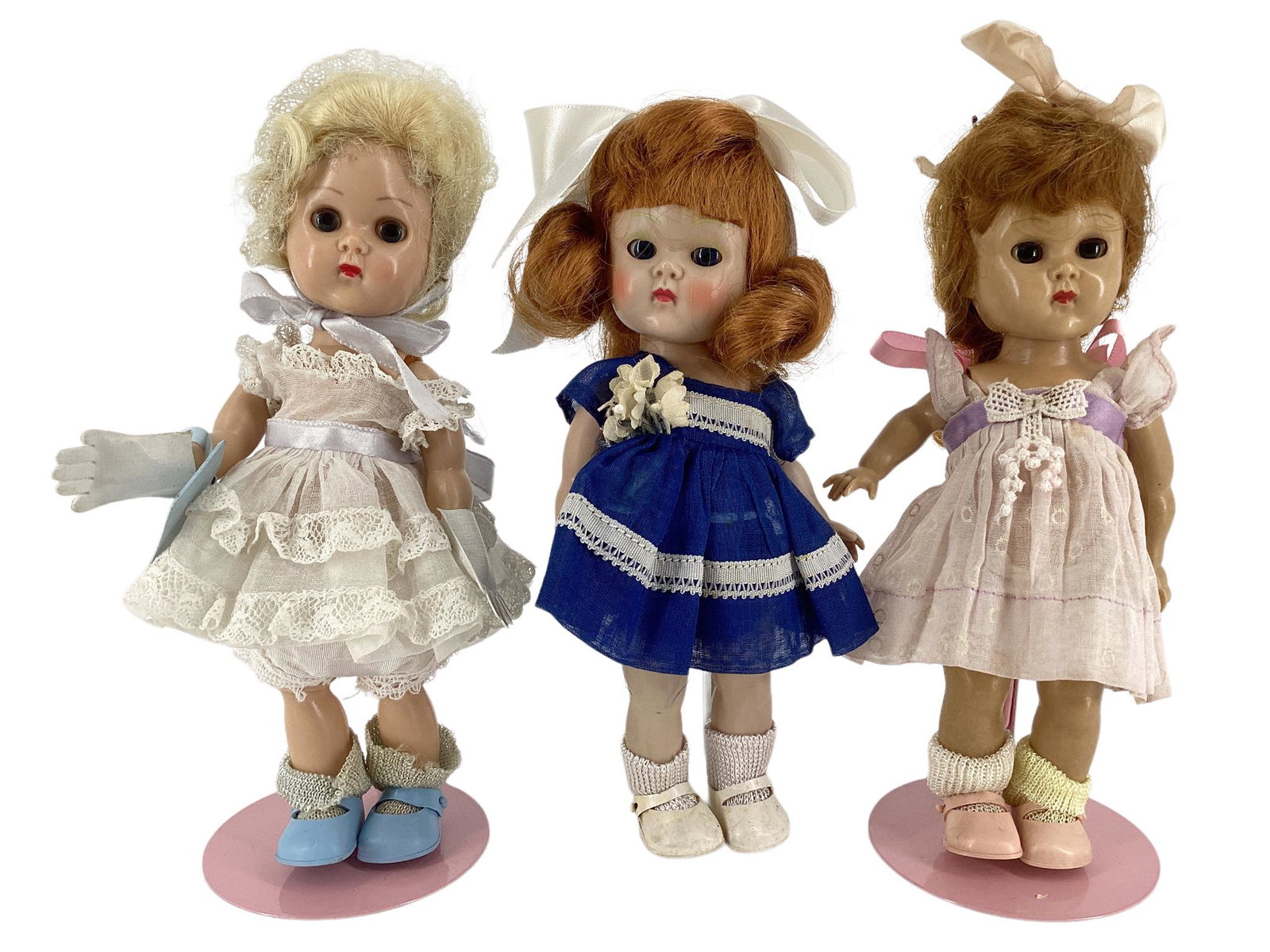 Lot of (3) 8" hard plastic Ginny dolls including red hair walker in untagged white and lavender: Lot of (3) 8" hard plastic Ginny dolls including red hair walker in untagged white and lavender dress (stain on bow), sleep eyes, molded eyelashes and painted facial features, red hair walker in tagge