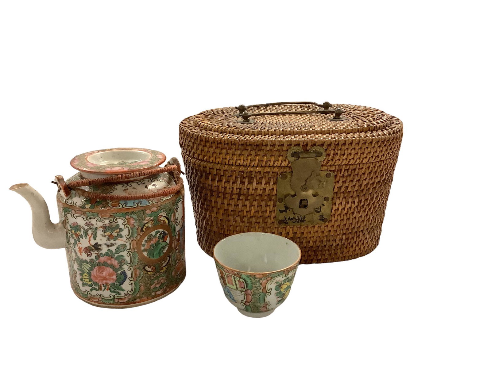 Asian Rose Medallion traveling tea set in padded basket. Basket is 8.5”L x 5”H. Teapot: Asian Rose Medallion traveling tea set in padded basket. Basket is 8.5”L x 5”H. Teapot is 4.5”H and has been repaired.