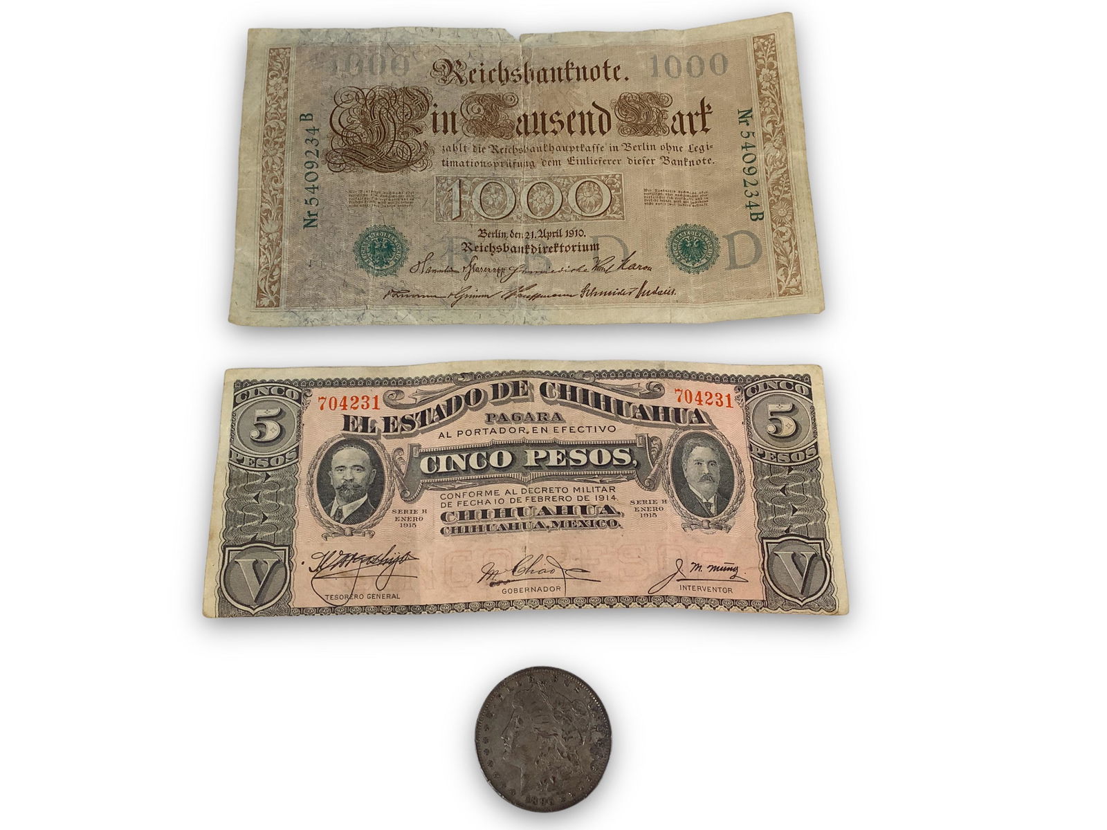 Two Foreign Bills + Morgan Silver Dollar Coin: Two Foreign Bills + Morgan Silver Dollar Coin 1915 series H State of Chihuahua 5 pesos note, 1910 1000 reichsbanknote (German), bills in circulated conditions with several folds. 1896-P Morgan silver