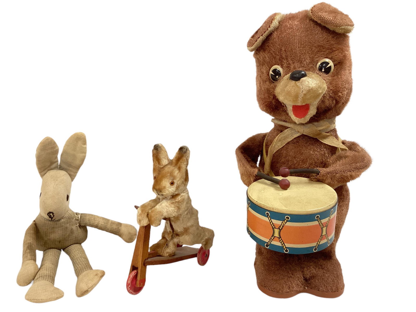 (3) older, untagged animal figures. 11î Drummer bear, with drum, made in Japan. 6î tan/: (3) older, untagged animal figures. 11î Drummer bear, with drum, made in Japan. 6î tan/ brown velvet rabbit on wood scooter, split front seam, wheels loose. 10î cloth rabbit (fiber fill
