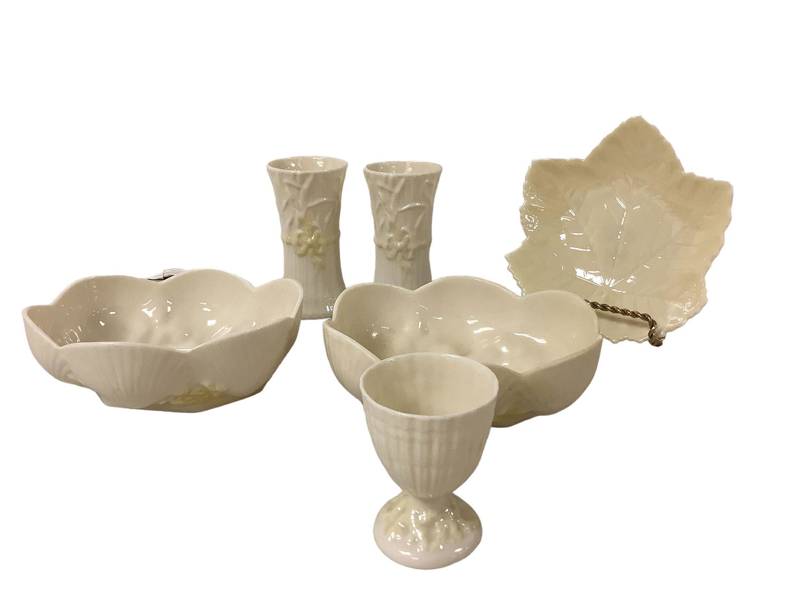 Belleek Accessory Lot: Six (6) piece lot of Belleek porcelain includes an egg cup, several matching shell-themed dishes, two matching small vases @ 4î tall w/yellow bows and a maple leaf dish.