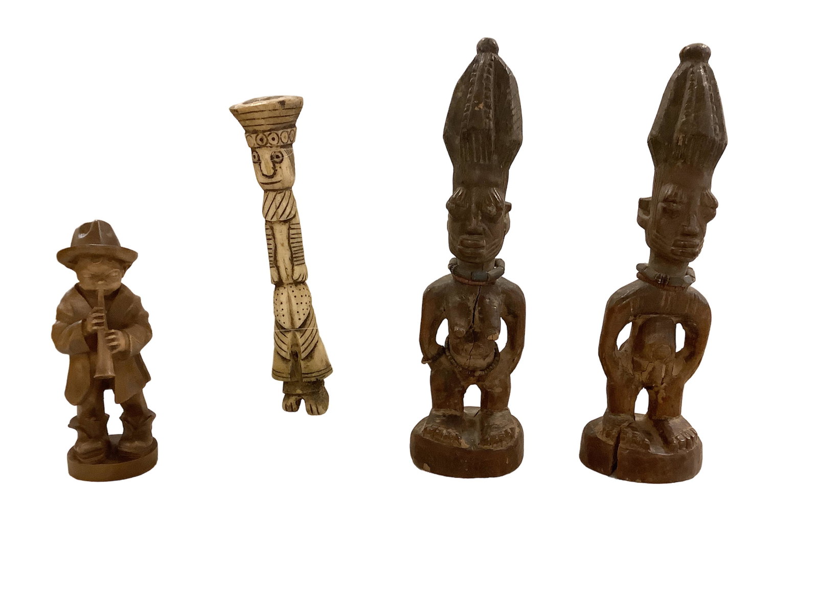 Assorted Wood Carvings: Assorted Wood Carvings Lot of 4 carvings: 6.75îH wooden boy playing a horn, 8.5îH bone totem attached to a lucite stand, 11îH wood African man and woman set (wood has some splits).