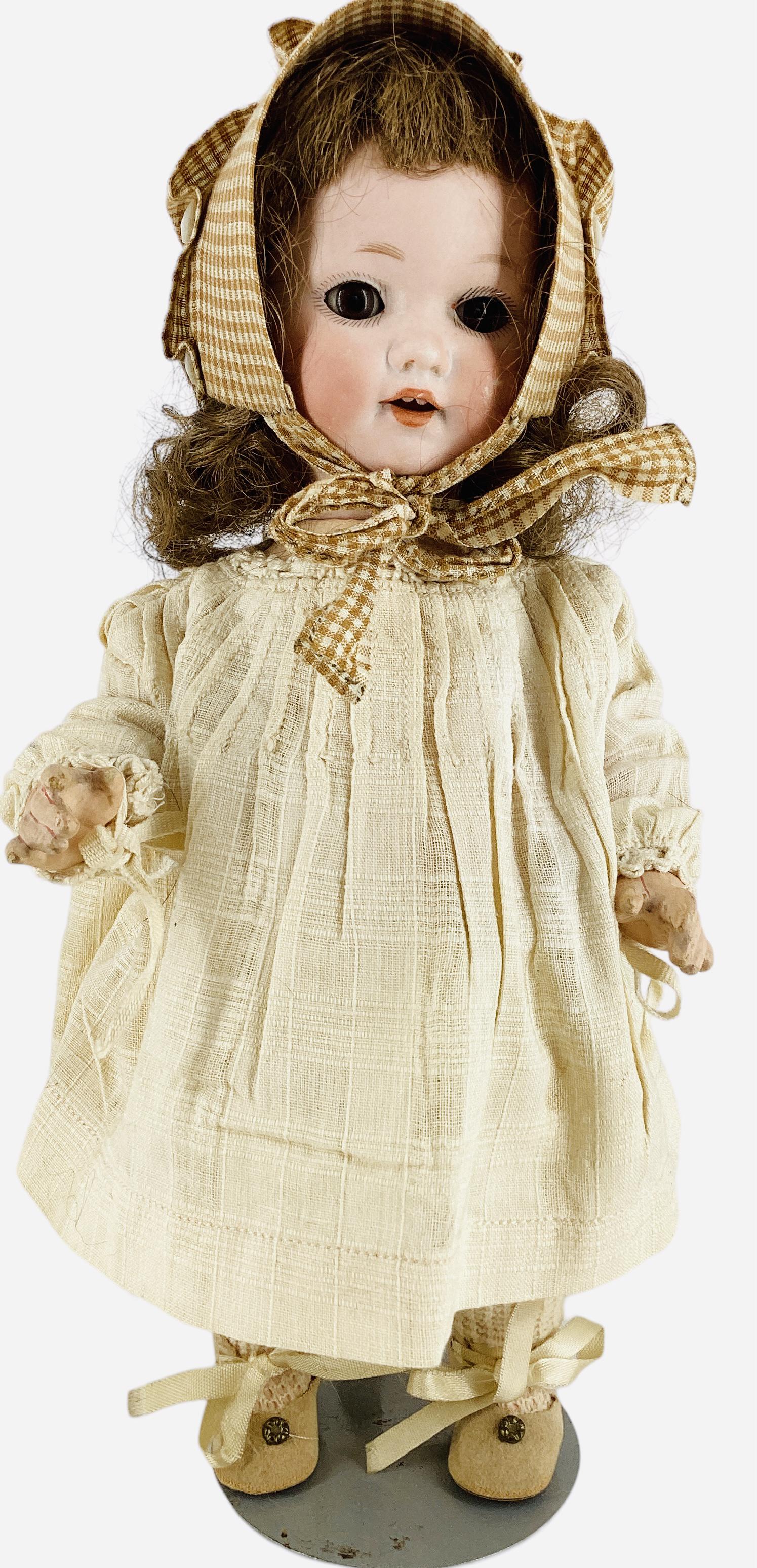 Armand Marseille 985 Bisque Socket Head Character Toddler: Armand Marseille 985 Bisque Socket Head Character Toddler 10" doll with replaced wig, glass sleep eyes, open mouth with teeth, on five-piece composition toddler body. Cheek rub left side of face.
