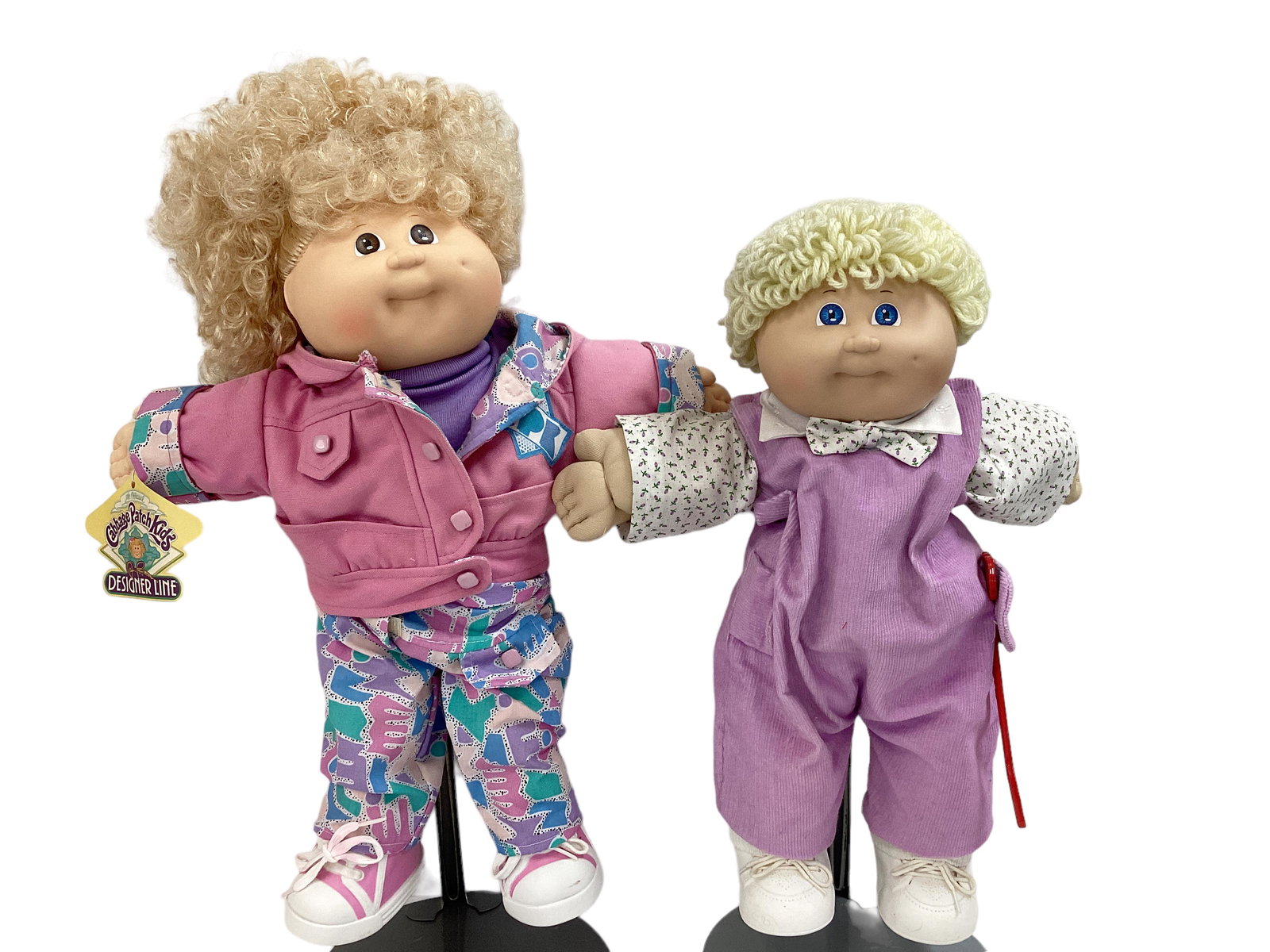 (2) Cabbage Patch Kids by Coleco 1985, 1989: (2) Cabbage Patch Kids by Coleco 1985, 1989 Designer Line doll in pink has blond cornsilk hair, original outfit, hanging tag, side tag, signature on bum. Doll in purple has yellow yarn hair, added too