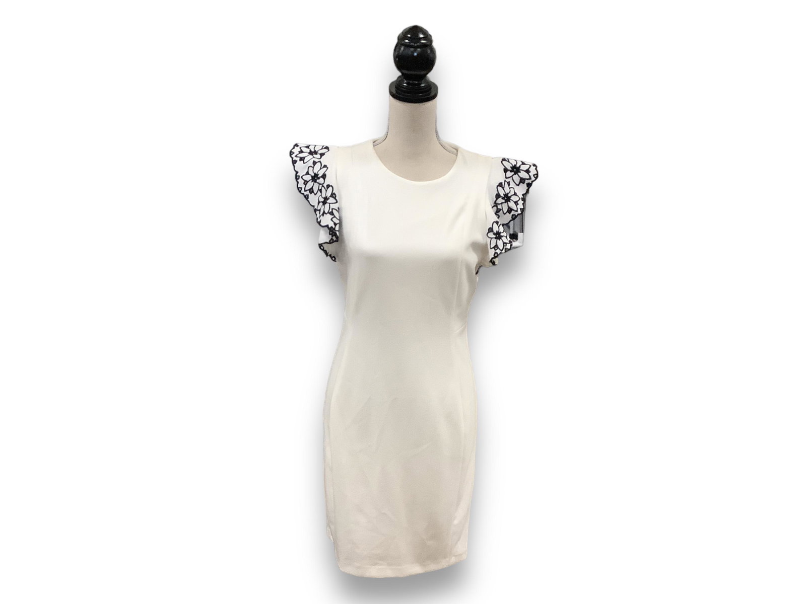 White Tommy Hilfiger Dress: White Tommy Hilfiger Dress Size (8) white, knee length dress. Features floral accented cap sleeves, and an invisible zipper up the back. 94% polyester and 6% spandex, dry clean only. Some blemishes on