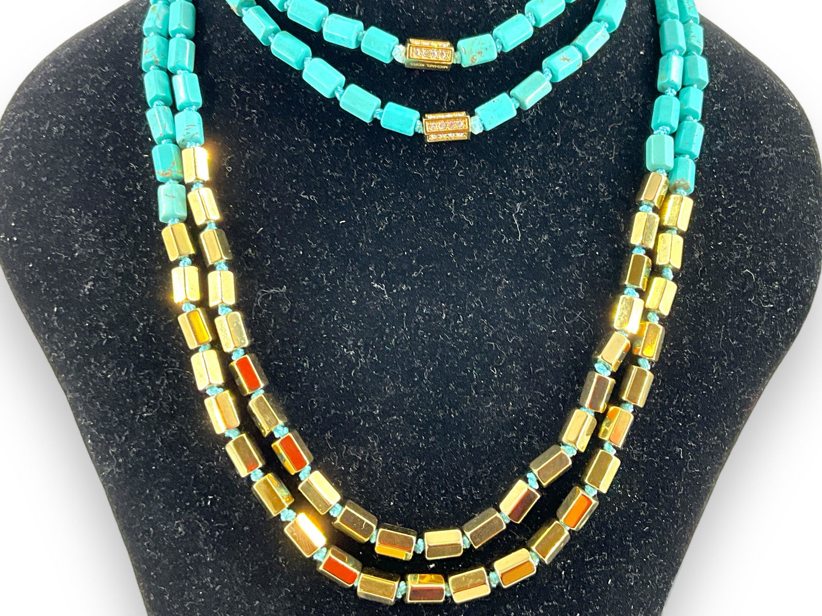 Two Michael Kors Necklaces: Two Michael Kors Necklaces Perfect for layering together, with measuring approx. 32î in length each featuring turquoise colored beads accented ith polished gold tone beads and accented with clear