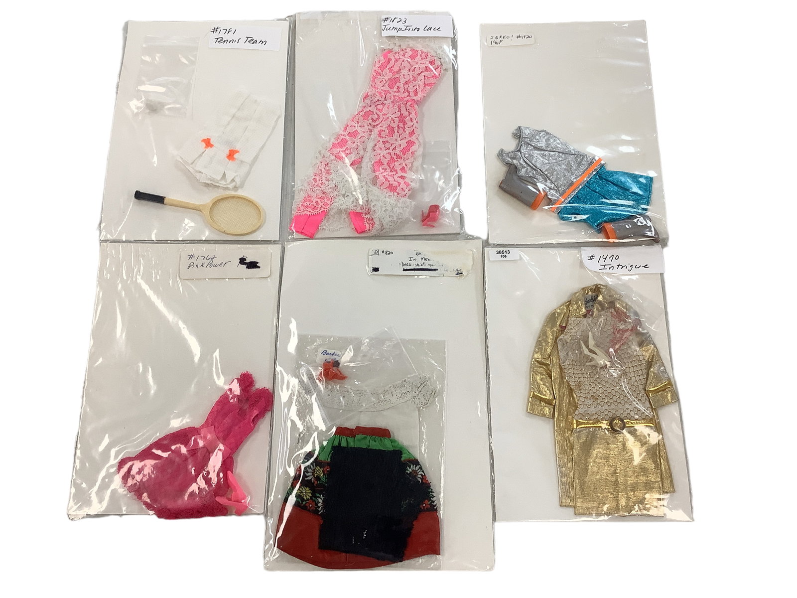 (6) VINTAGE BARBIE OUTFITS: (6) VINTAGE BARBIE OUTFITS (6) outfits including: Intrigue (dress,coat,off white pumps), Barbie In Mexico (dress,skirt,black mantila,red heels), Pink Power (dress,shoes), Zokko! (dress,boots), Jump In
