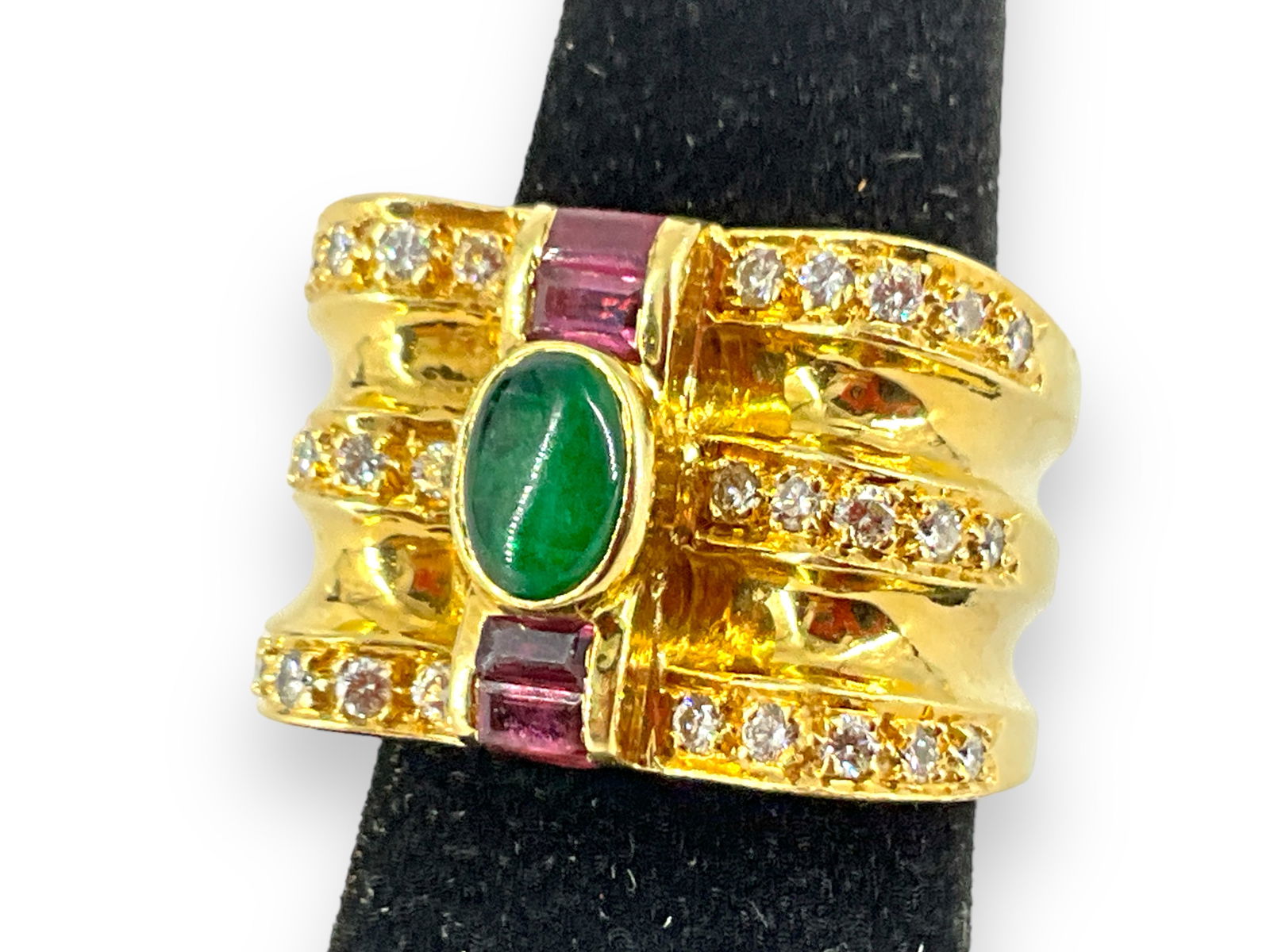 Impressive 18k Wide Band Ring: Impressive 18k Wide Band Ring Bold ring is tested 18k, no hallmarks found. Piece is a size 7 and has a center oval emerald cabochon measuring approx 6.7 x 4.5mm, 6 baguette rubies, each measuring appr