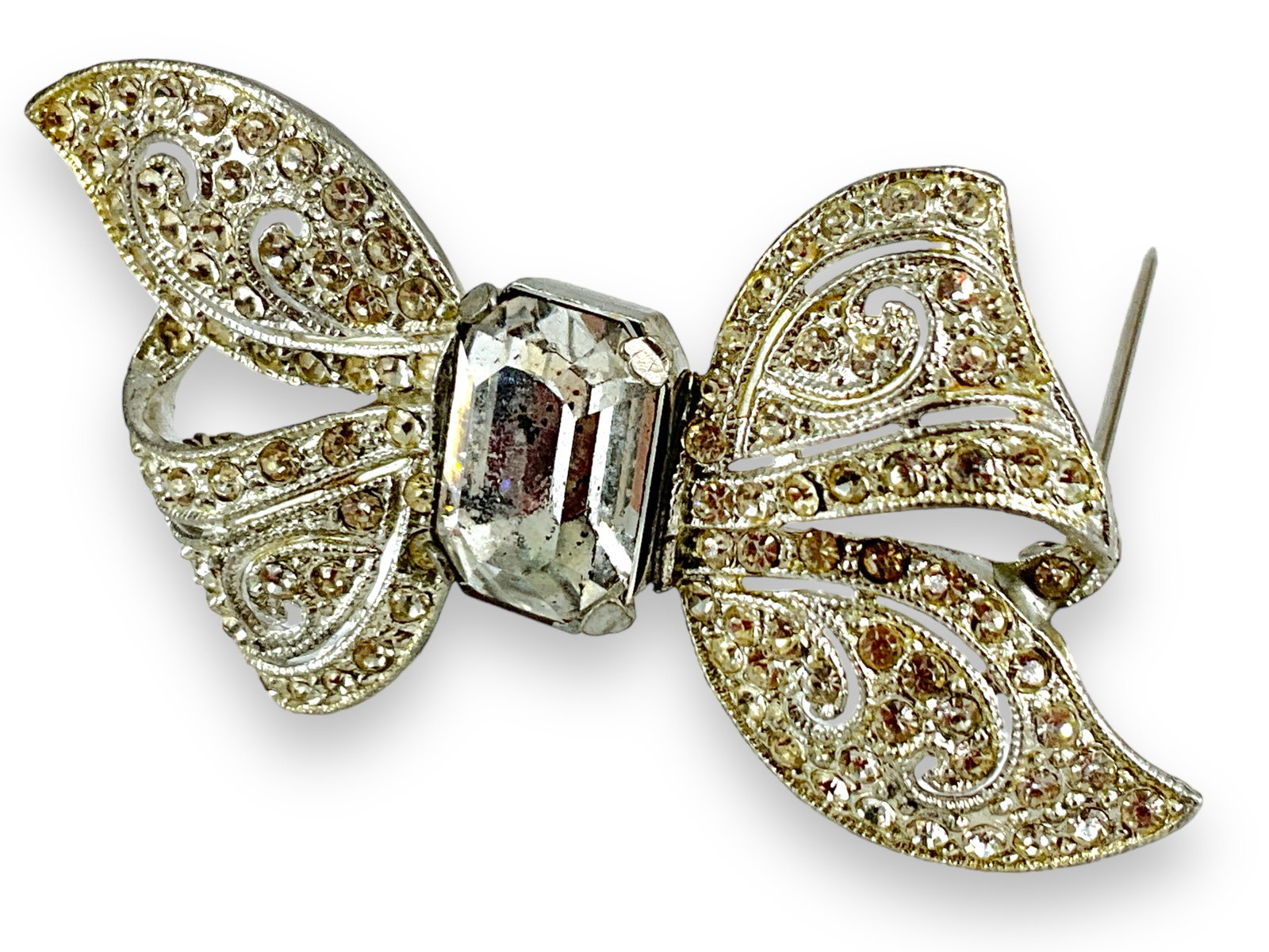 Elegant Rhinestone Bow Pin: Elegant Rhinestone Bow Pin Measuring approx. (2.95î x 1.52î) featuring an openwork scroll motif in the center and millgrain accents along the edges.