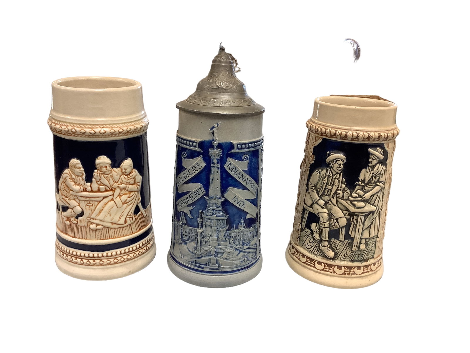 Steins: Steins Lot of 3. (1) made in Germany 6.5î T (1) made in Japan 6.5 T and one from Indianapolis Indiana with pewter lid 6î T.