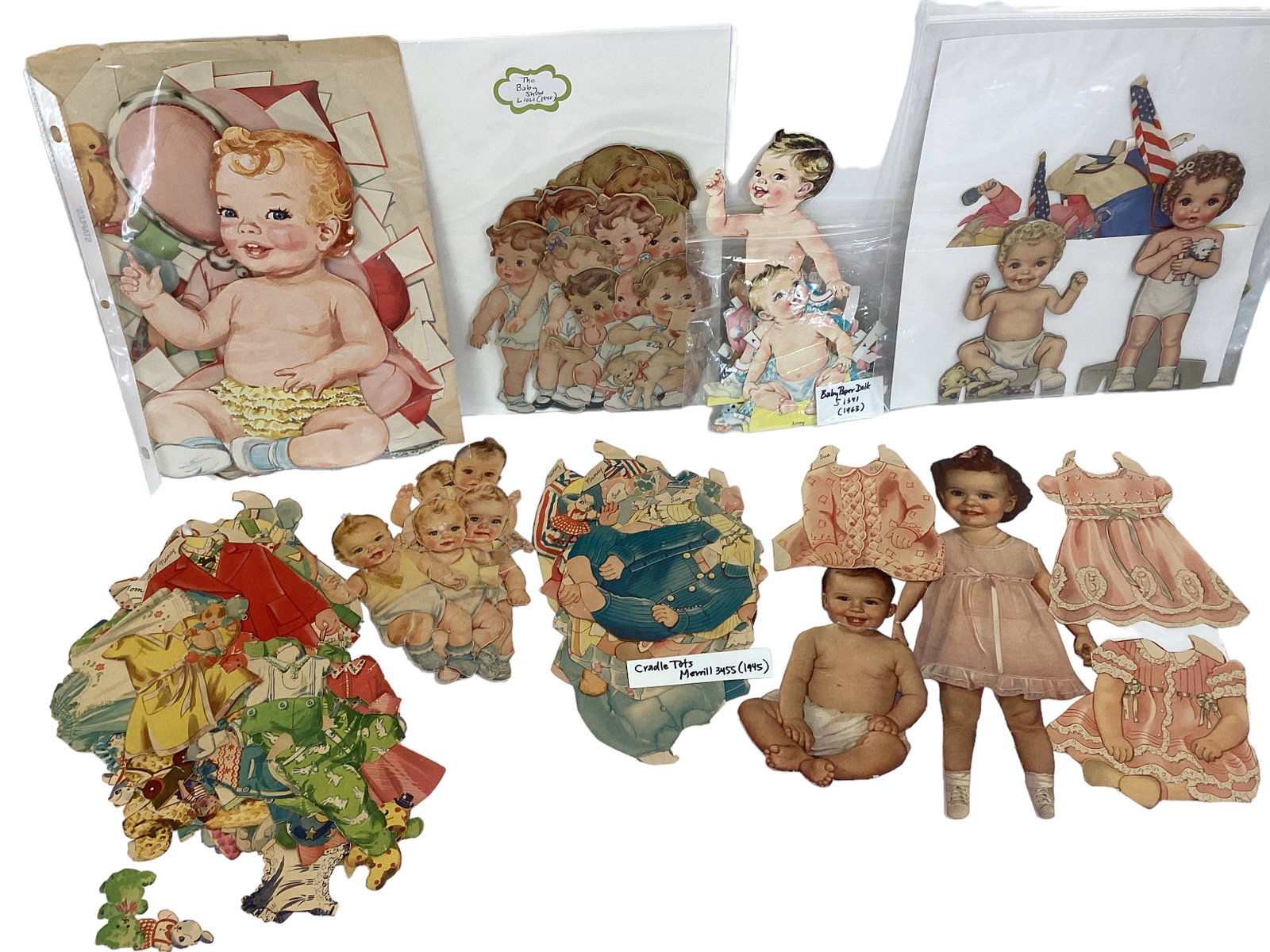 Assortment of Baby Paper Dolls & Clothes: Assortment of Baby Paper Dolls & Clothes All dolls & clothes have been cut. Over 20 figures, at least that many outfits. Dates range from 1940, 1945, 1963. Some are paper, others backed on cardboard.