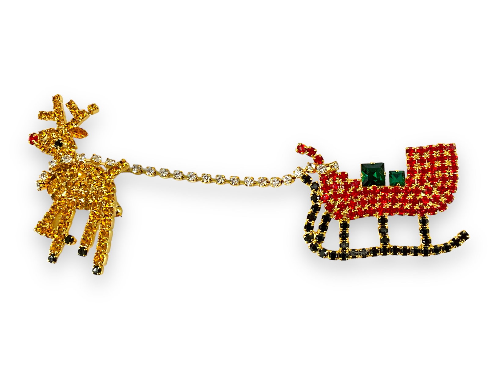 Rudolph & Sleigh Pin: Rudolph & Sleigh Pin Rhinestone pin measuring approx. (4.69î x 1.75î) featuring good old Rudolph pulling Santaís slay with sharp green presents in tow, attached with a line of clear rhi