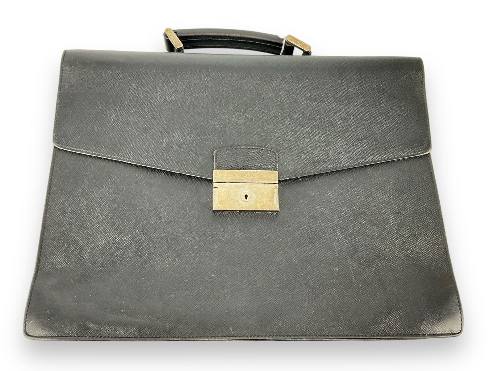 Prada Black Leather Briefcase: Prada Black Leather Briefcase Used condition with some minor damages to interior of bag, approximately 15" x 11.5" in size, branded clasp and elements, made in Italy.