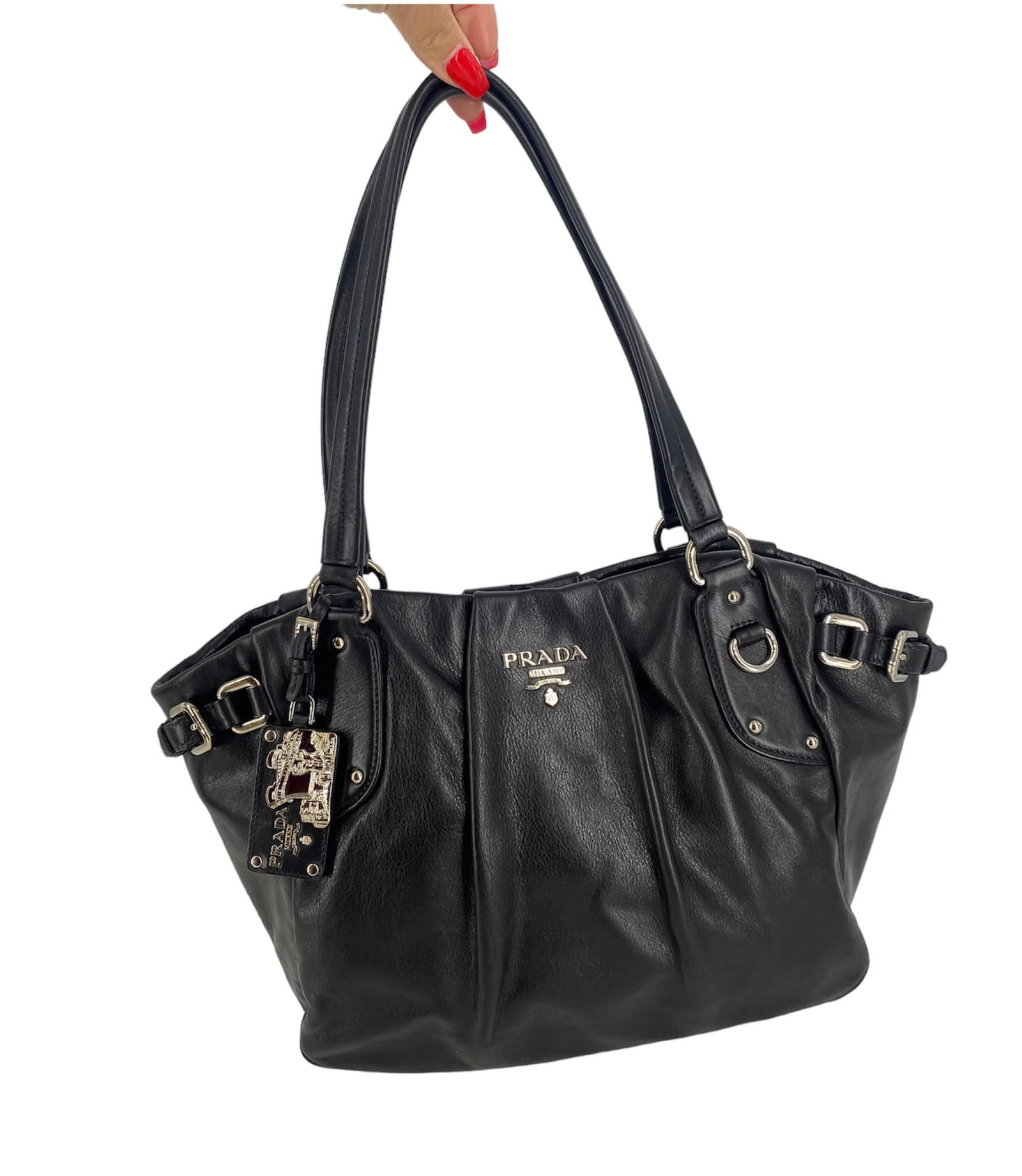 Black Leather Prada Handbag: Black Leather Prada Handbag Measuring approx. (16.5î x 5î x 10î) with a double handled drop of (8.75î) like new condition, polished silver tone hardware with a bag charm featuring