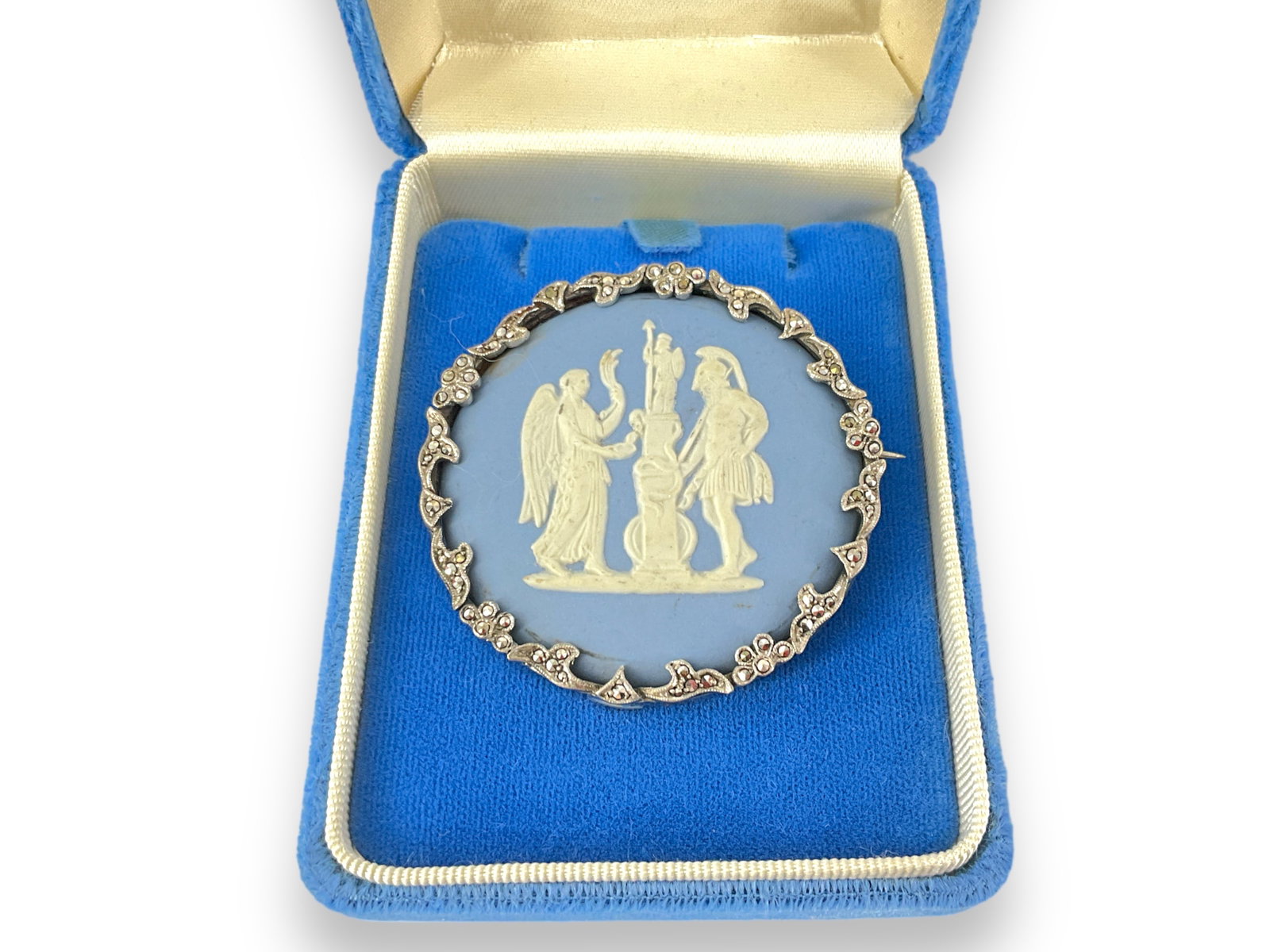 Beautiful Blue Wedgwood Brooch w/Marcasite Border: Beautiful Blue Wedgwood Brooch w/Marcasite Border Circular brooch is signed on reverse ìWedgwood Made in England 1956 EGî and is 2î wide. Brooch frame tests as silver and has marcasite 