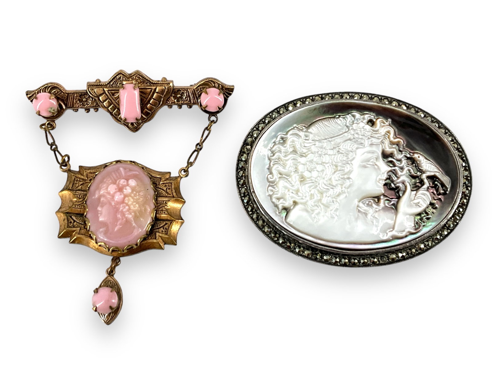 Vintage/Antique Costume Jewelry: Vintage/Antique Costume Jewelry Tested as primarily copper, vintage brooch is styled as a bar brooch with a drop swing-section featuring a likely glass pink cameo and accent pieces. Piece is approx 2&