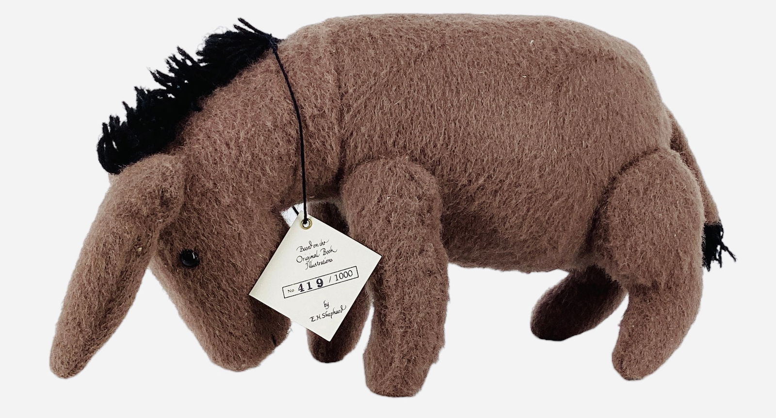 R. John Wright "Eeyore".: R. John Wright "Eeyore". 9 1/4" long wool felt donkey with applied ears, shoe button eyes, jointed at the neck, shoulders and hips. Limited Edition No. 419/1000, comes in original box with hang tag. P