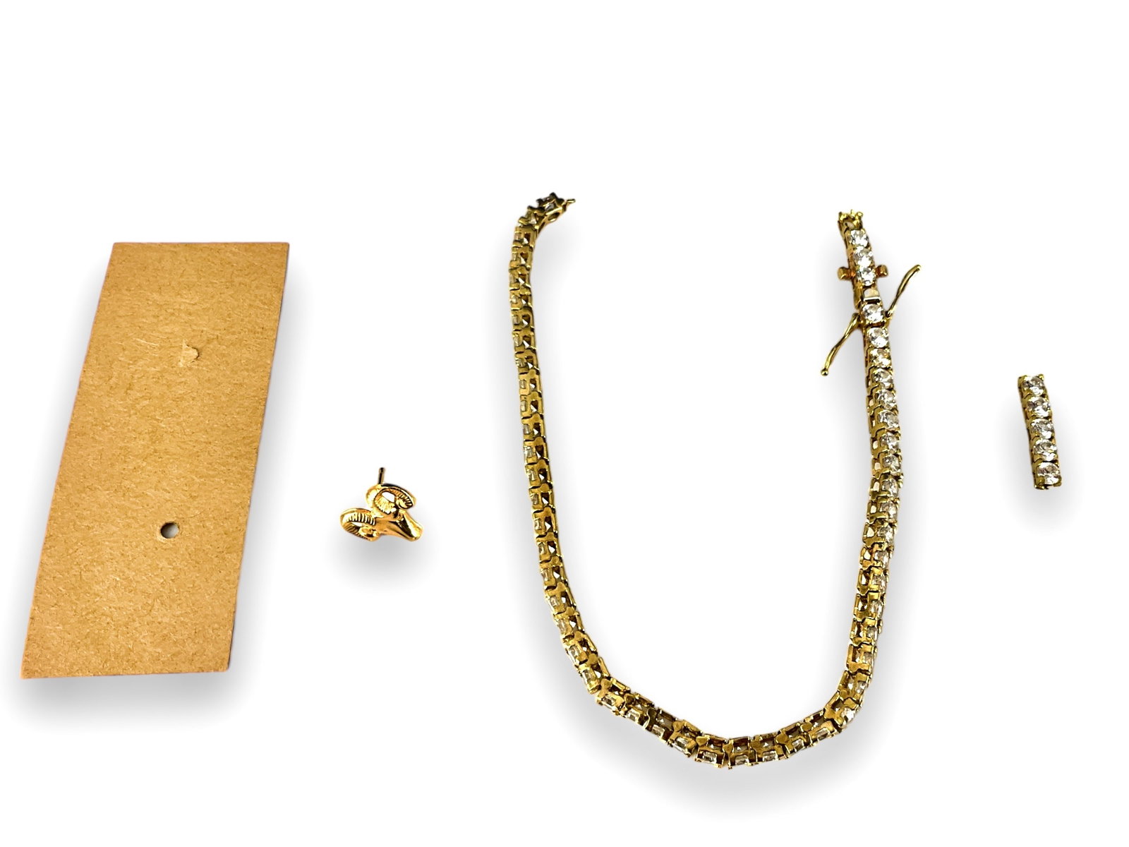 Scrap Gold: Scrap Gold One post back earring featuring a rams head (0.2 grams tw) and one broken 10kt yellow gold cz stone tennis bracelet - damaged (8.8 grams tw).