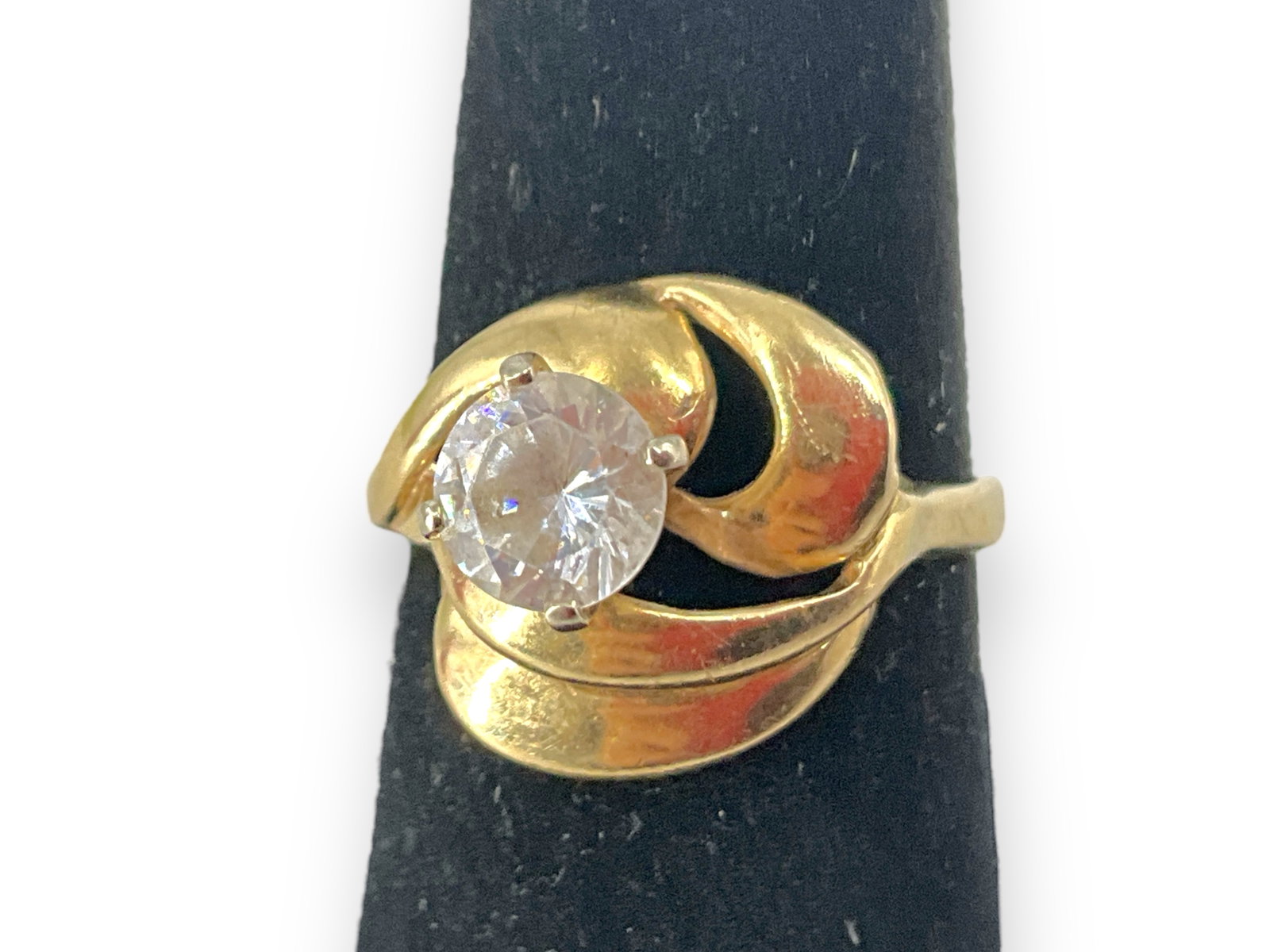 14K Ladies Ring with CZ Center: 14K Ladies Ring with CZ Center Ladies ring is a size 7.5 and weighs 4.78 grams, has a swirl design top with a Cubic Zirconia solitaire center @ approx 1 carat.