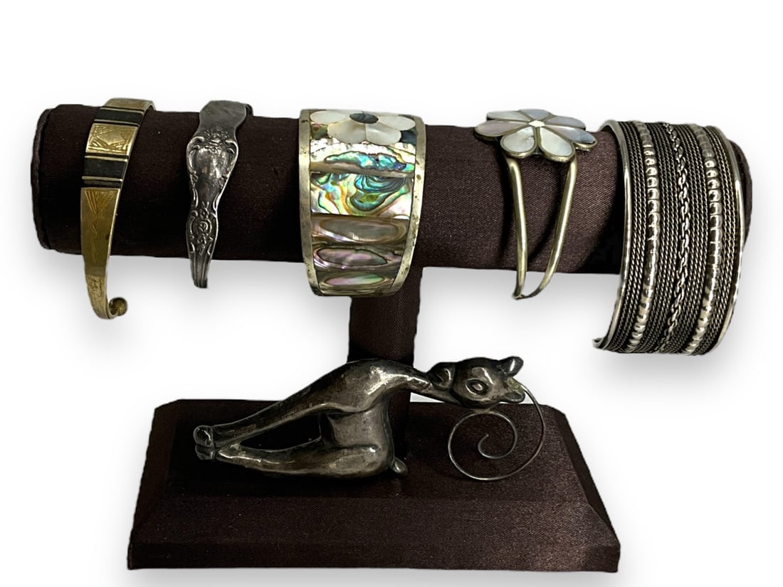 Five Silver-Tone Fashion Bracelets and Silver Deer Pin: Five Silver-Tone Fashion Bracelets and Silver Deer PinLot has five silver-tone (or low silver content) open-cuff bracelets, one has inlaid abalone and mother-of-pearl with an approx 5" interior circum