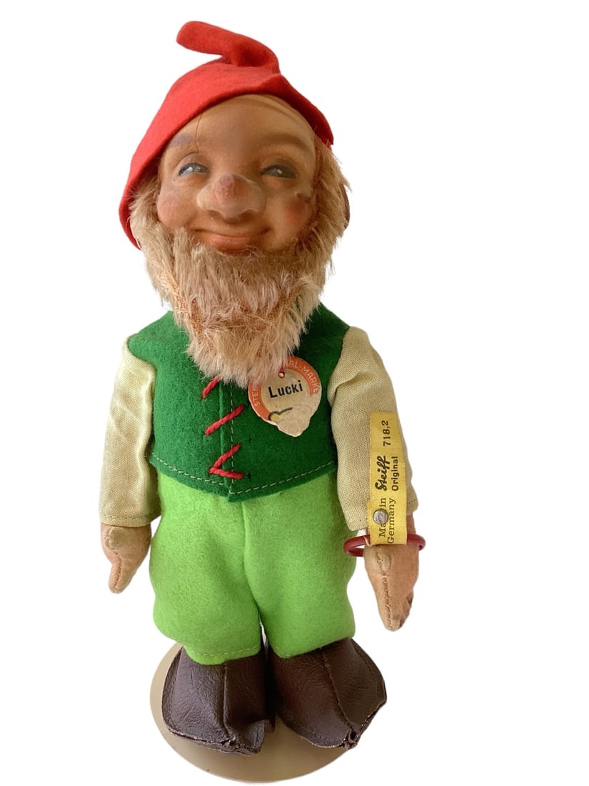 7" "Lucki" Gnome by Steiff: 7" "Lucki" Gnome by Steiff With button tag, paper chest tag. Plastic head (has crack from eye to top of head & back of head), jointed arms, felt stuffed body. Rub on nose. Original string on hat.
