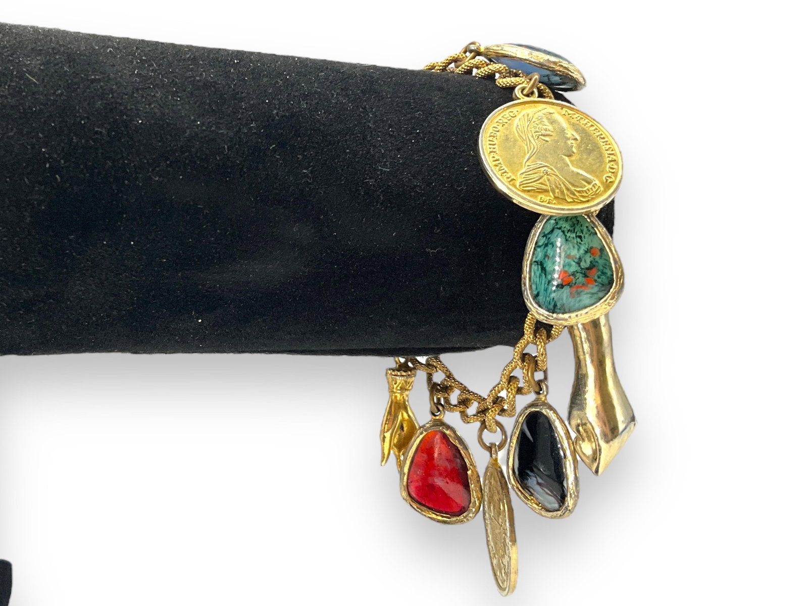Vintage Costume Bracelet: Vintage Costume Bracelet Measuring (7") in length from Accessocraft New York with ornate glass charms, fist and hand charms, and foreign coin style charms, spring ring clasp closure.