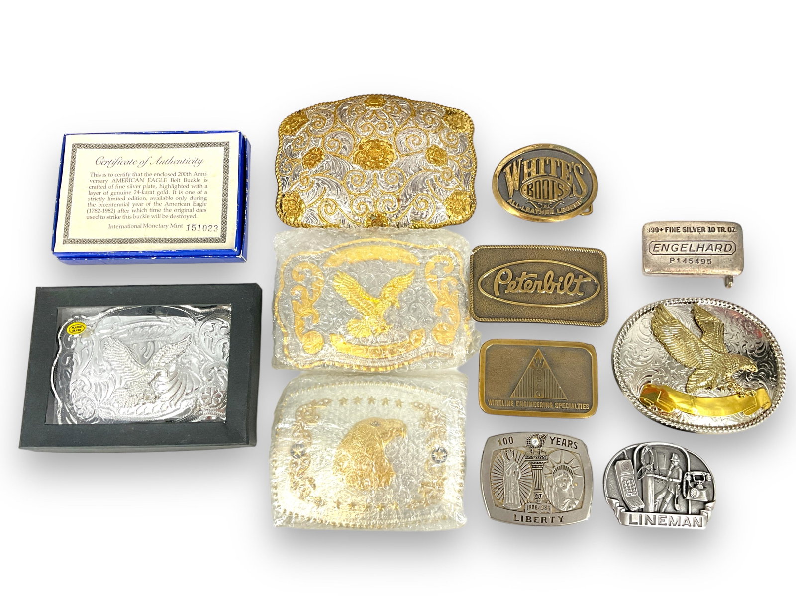 Assortment of Belt Buckles: Assortment of Belt Buckles Men's belt buckles, over-sized designs, include patriotic/eagle motifs and business-related designs, approximately ten in total, mixed conditions including like-new and used