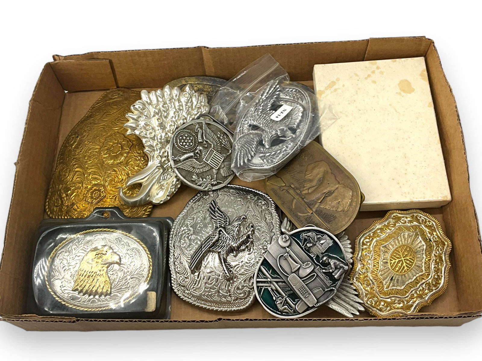 Assortment of Belt Buckles: Assortment of Belt Buckles Men's belt buckles, over-sized designs, include patriotic/eagle motifs and business-related designs, approximately ten in total, mixed conditions including like-new and used