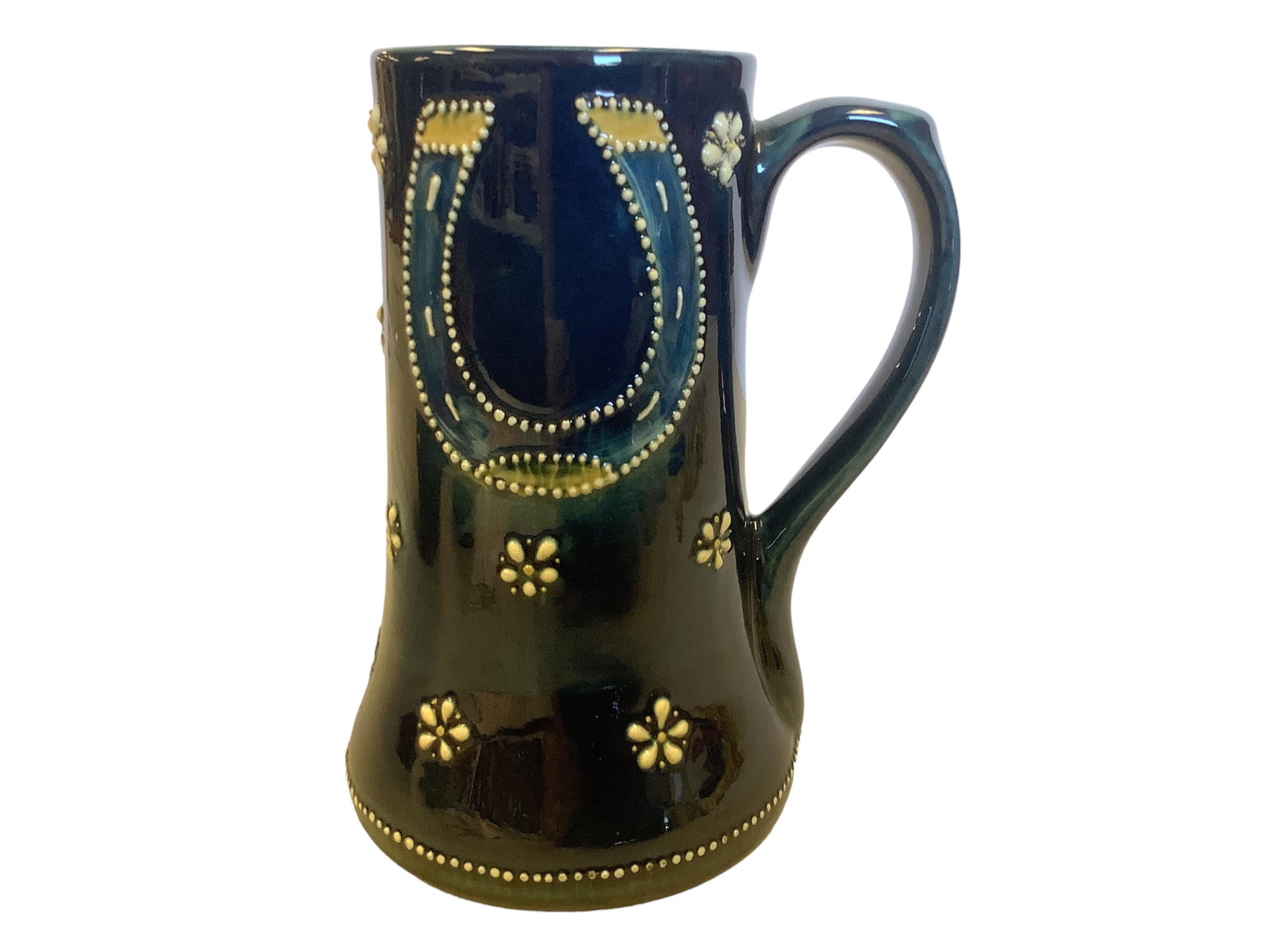 Art Pottery Mug 6.75"H with a 3" opening: Art Pottery Mug Dark blue/green with raised horseshoe and daisy decoration. Marked "327". 6.75"H with a 3" opening