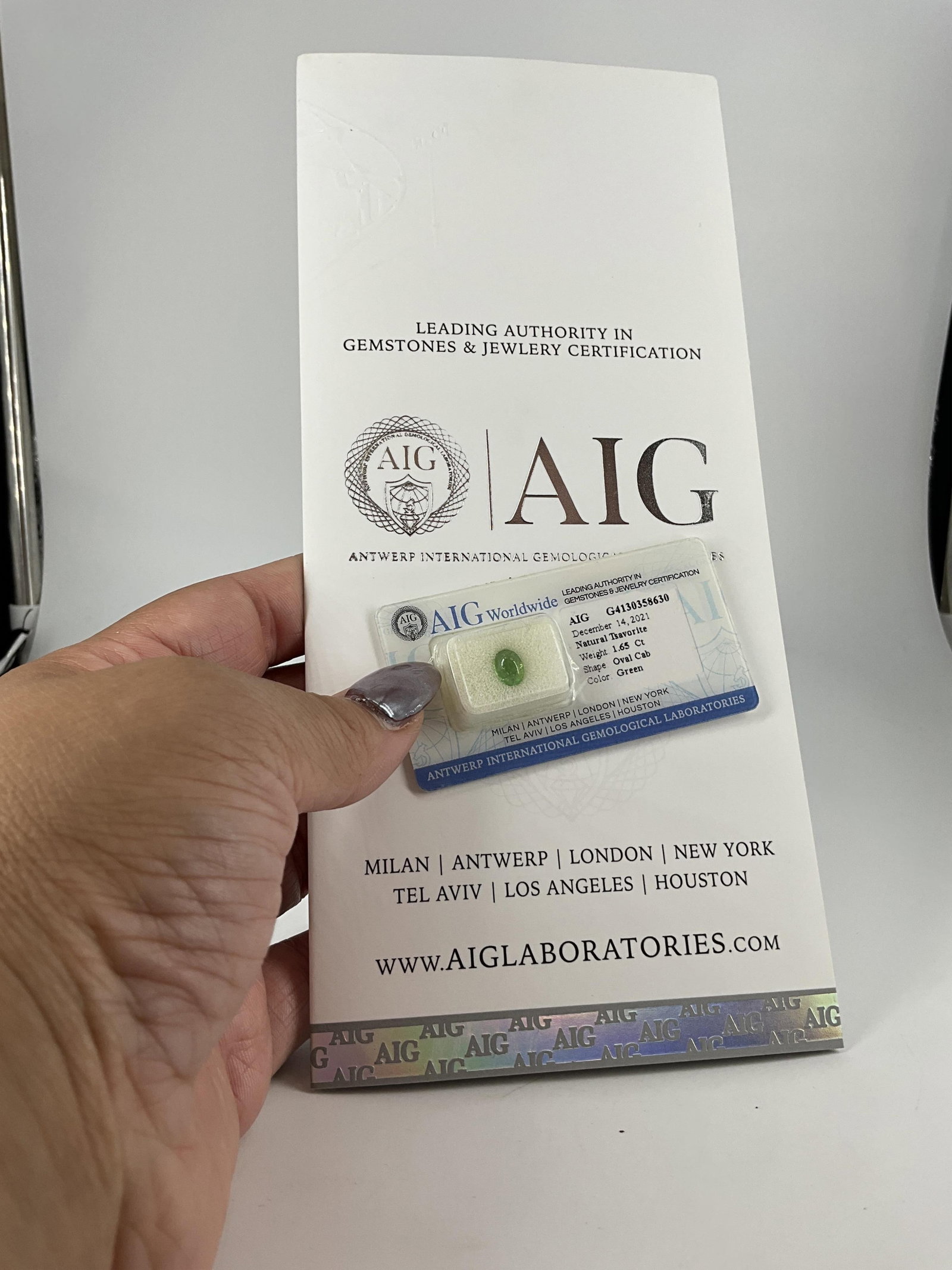 Loose Natural Green Garnet With AIG Report: Loose Natural Green Garnet With AIG Report (1.65ct) cabochon measuring (8.01mm x 5.93mm x 3.65mm) natural gemstone, transparent, in sealed AGL case with report. Insurance replacement value - $1,500.00