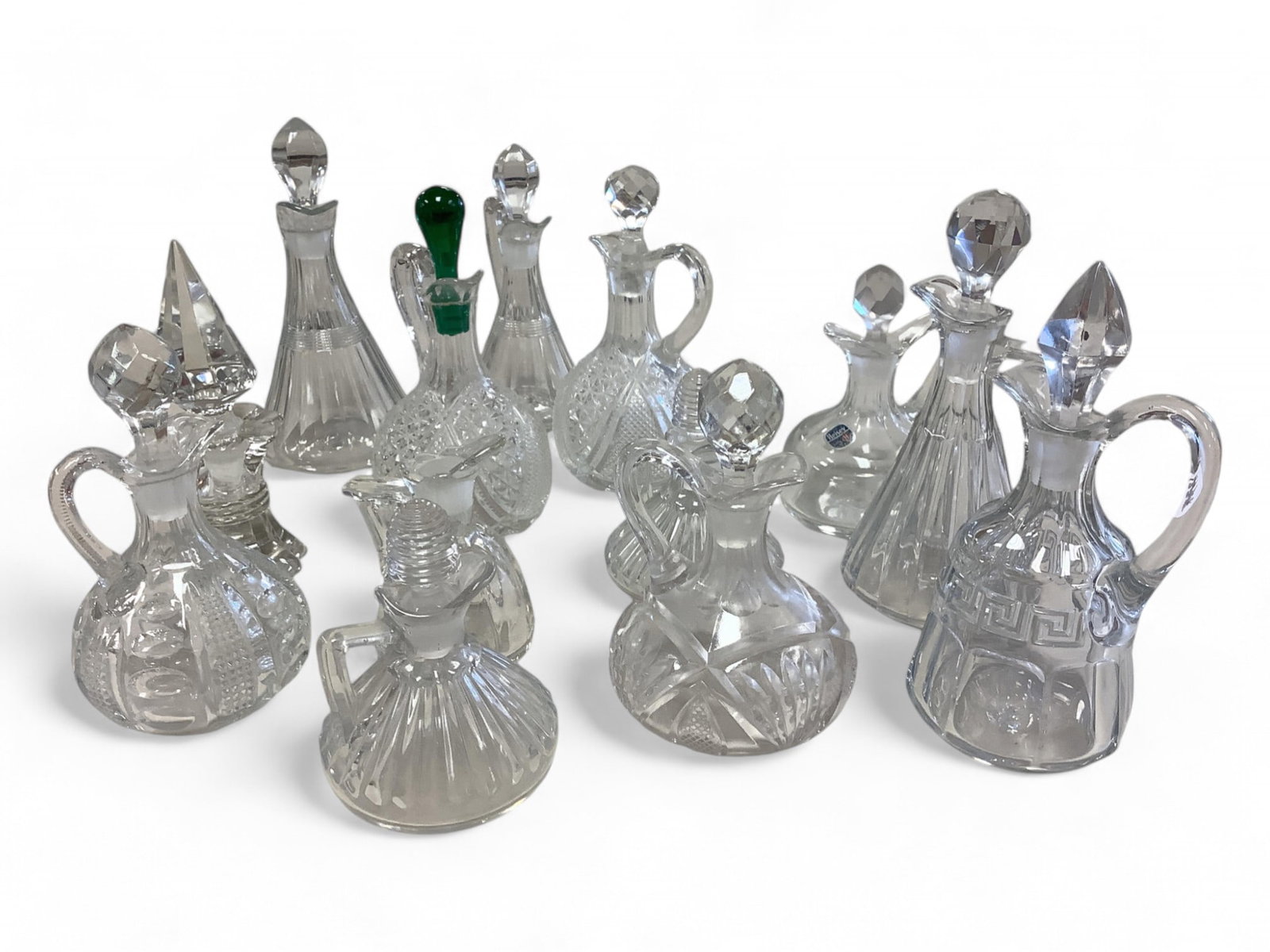 Collection of Heisey Cruets Lot of 12: Collection of Heisey Cruets Lot of 12 No. 150 Banded Flute 4 oz. Unmarked. No. 1255 Pineapple and Fan 6 oz with faceted stopper. No. 1404 Old Sandwich 3 oz. No stopper H. Two No. 1469 Ridgely 3 oz wit