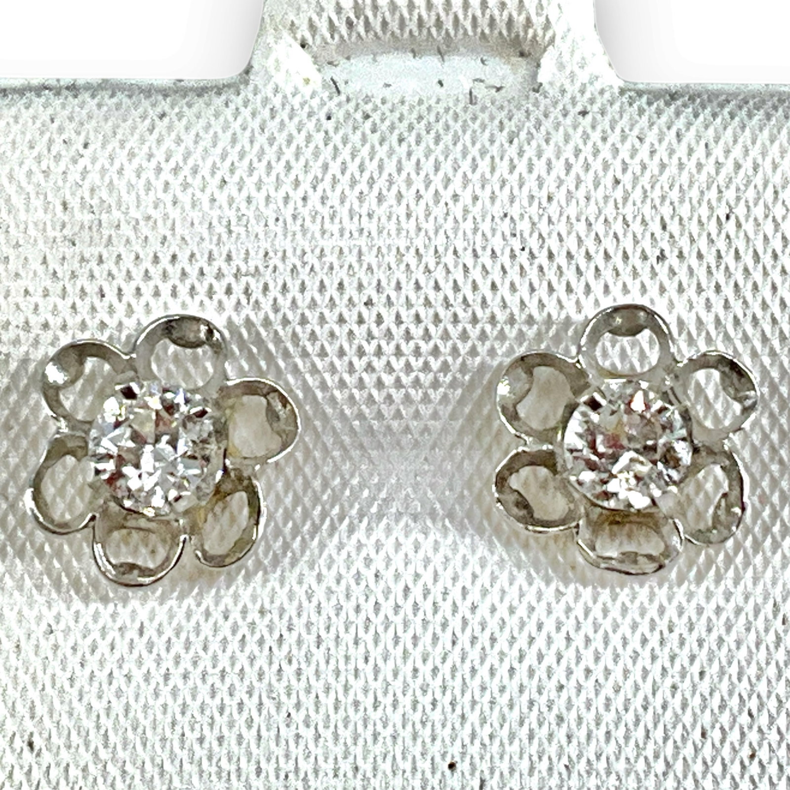 14kt White Gold and Diamond Earrings: 14kt White Gold and Diamond Earrings Stamped and tested 14kt white gold, 1.5 grams total weight, pierced style with scalloped mountings, with a pair of 4.0mm diamond rounds, diamonds approximately 0.5