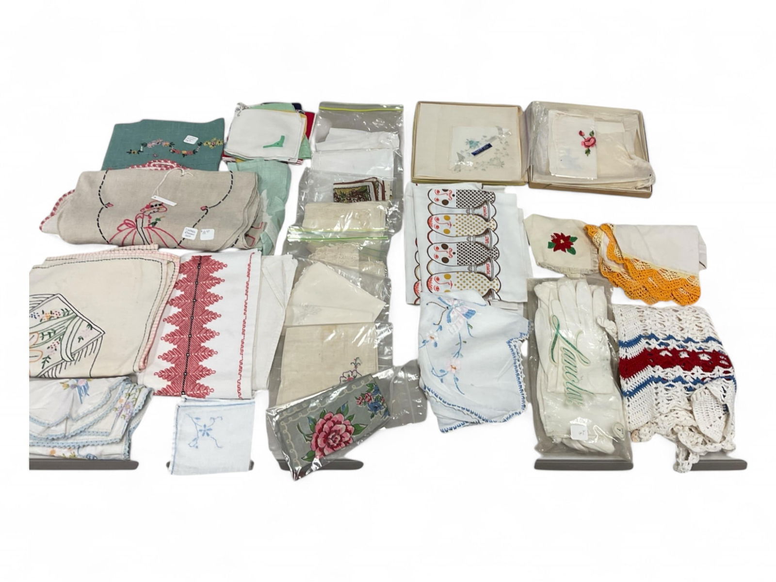 Lot of Crocheted and Cross Stitch Doilies and Handkerchiefs: Lot of Crocheted and Cross Stitch Doilies and HandkerchiefsCrocheted apron. 2 pairs of white gloves.