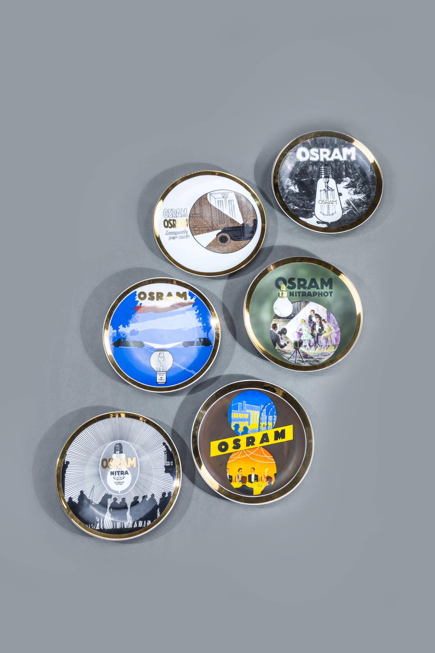 PIERO FORNASETTI: PIERO FORNASETTI Milano 1913 - 1988 Six plates of the series Vintage lamps White ceramic decorated with silk-screen printing. Series created for "a small number of Osram friends" Mark and number 1 to