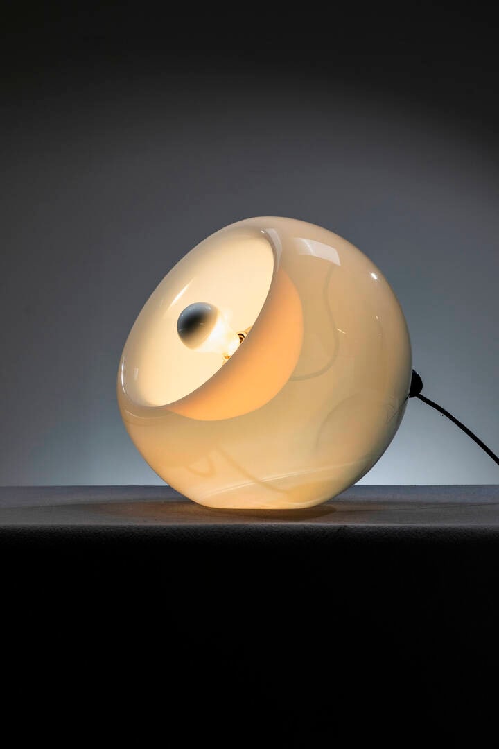 ELEONORE PEDUZZI RIVA: ELEONORE PEDUZZI RIVALampada da tavolo mod. VacunaStruttura in vetro opalino.Prod. Artemide, anni '60h cm 42x46x40